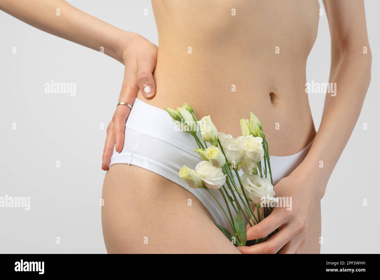 Jeune femme en lingerie blanche avec fleurs Banque D'Images