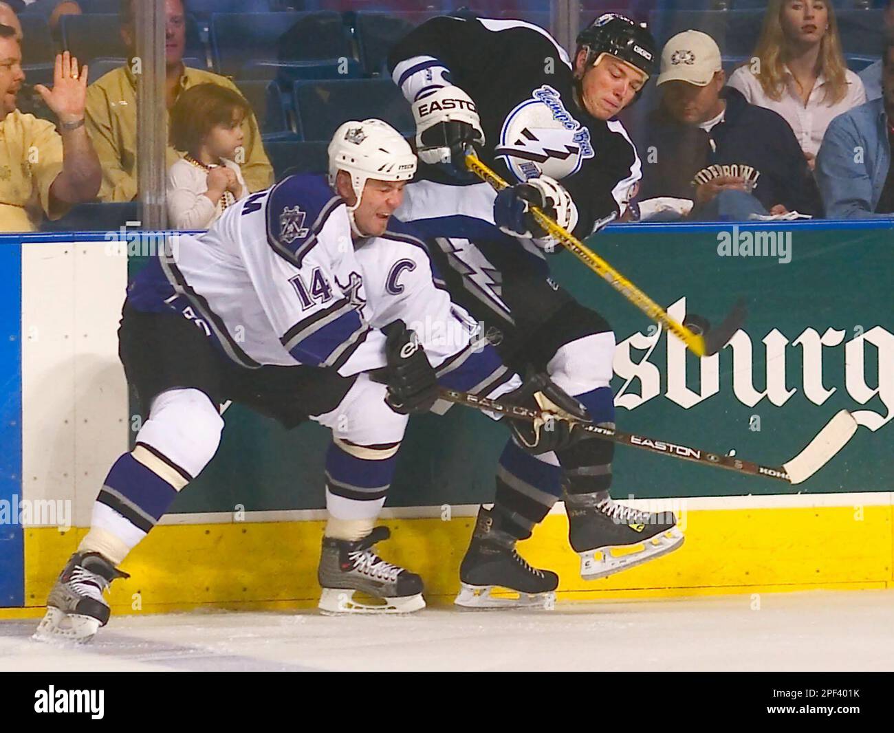 The puck slides down the stick of Tampa Bay Lightning right wing Ruslan Fedotenko, right, of Ukraine as he battles Los Angeles Kings defenseman Mattias Norstrom (14) of Sweden along the boards during the first period Thursday night, Nov. 6, 2003, in Tampa, Fla. (AP Photo/Steve Nesius) Banque D'Images