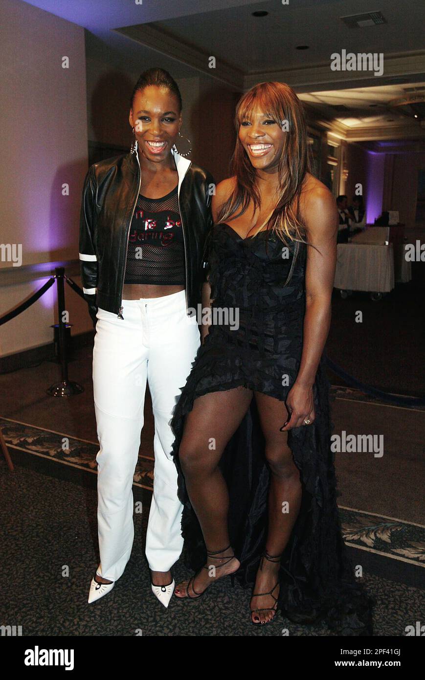 Tennis stars Venus Williams, left, and her sister Serena Williams fashion their new clothing line during WTA Tour Charities Gala on Monday, Nov. 3, 2003, in Santa Monica, Calif. (AP Photo/Kevork Djansezian) Banque D'Images