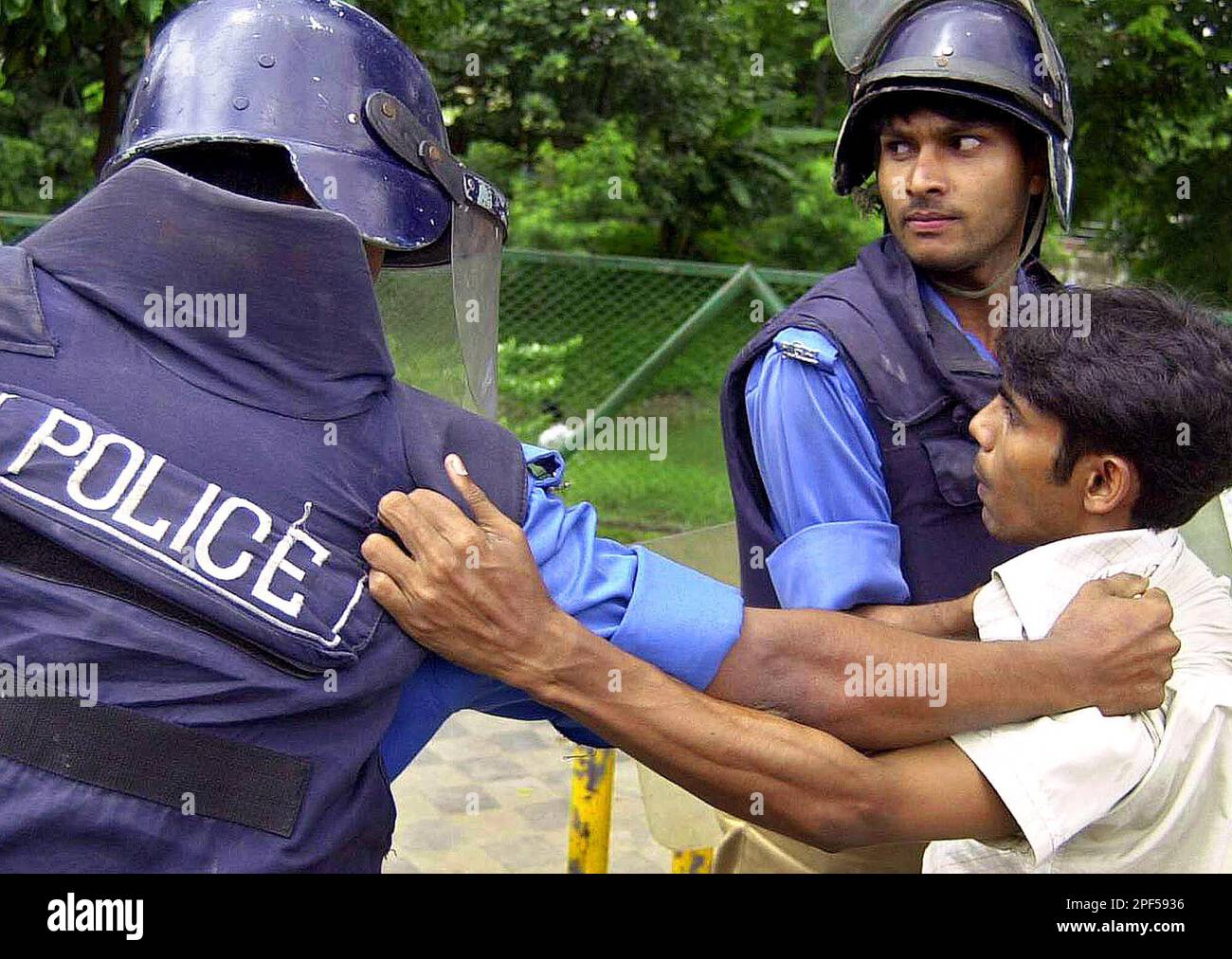 Bangladeshi riot police detain an opposition activist during a dawn-to-dusk nationwide strike in Dhaka, Bangladesh, Bangladesh, Aug. 28, 2003. The general strike, called by the countrys main opposition party the Awami league, was to protest the killing of opposition leader Manzurul Imam in Southwest Bangladesh Monday. (AP Photo/Pavel Rahman) Banque D'Images
