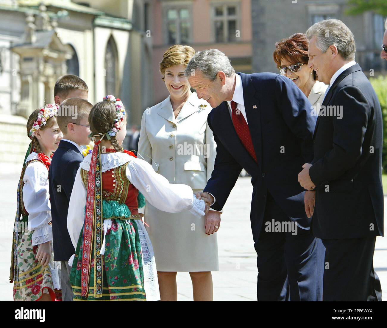 Poland's President Aleksander Kwasniewski and Polish first lady Jolanta Kwasniewska, right, welcome U.S. President George W. Bush and first lady Laura Bush at Wawel Castle in Krakow, Saturday, May 31, 2003 as they are greeted by children in tradional dress. President Bush is scheduled to travel later to St. Petersburg, Russia and then Evian, France for the G-8 Economic Summit. (AP Photo/J. Scott Applewhite) Banque D'Images