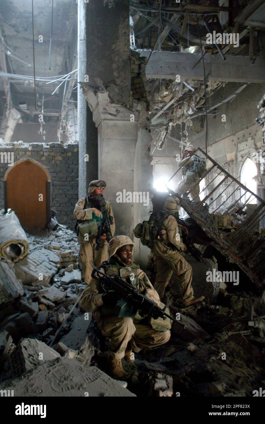 U.S. Army soldiers from A Company, 3rd Battalion, 7th Infantry Regiment, search one of Saddam Hussein's palaces damaged after a bombing, in Baghdad Monday, April 7, 2003. Coalition soldiers took over key buildings Monday, as gunfire and explosions thundered in many parts of the battered Iraqi capital. (AP Photo/John Moore) Banque D'Images