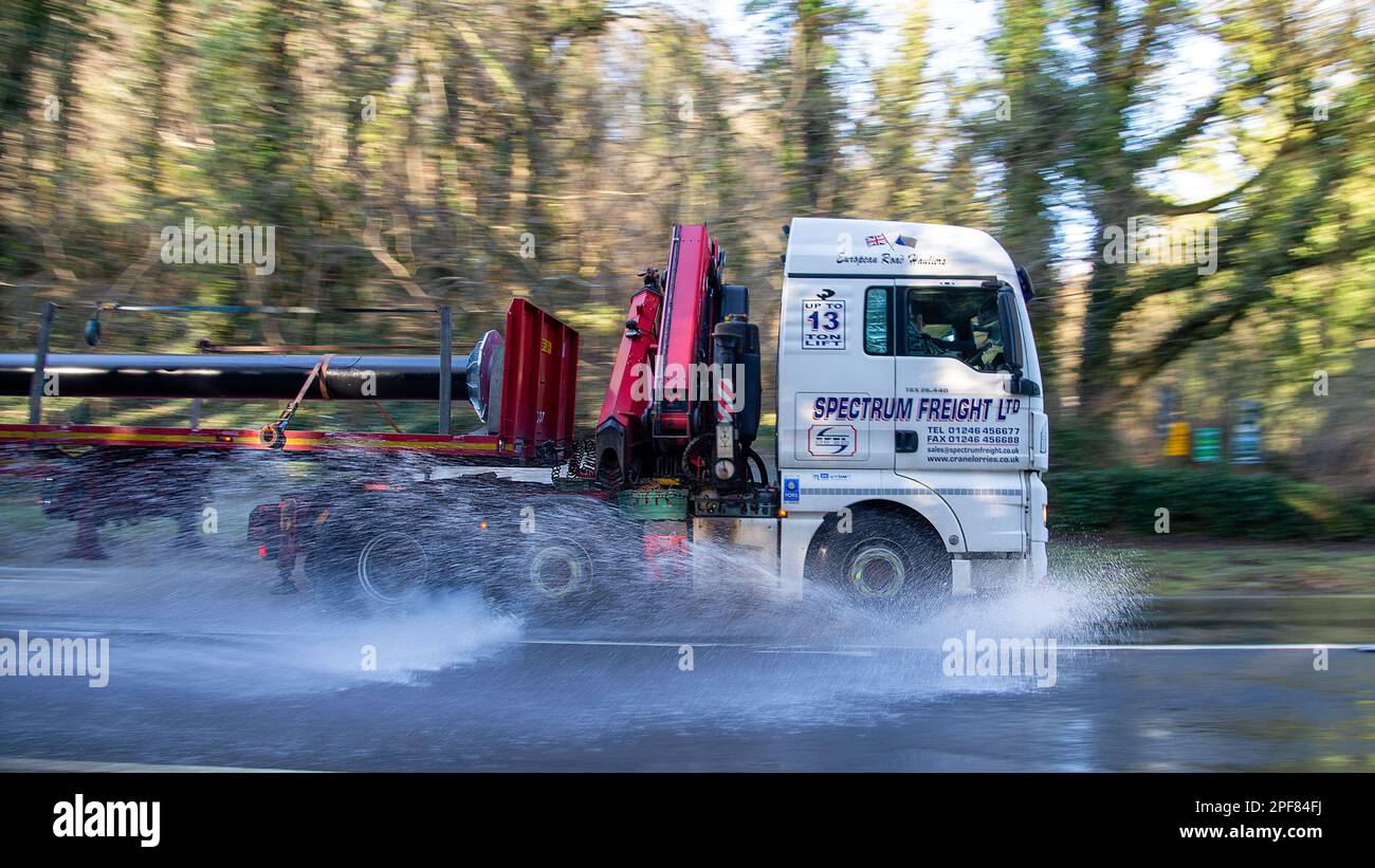 Camion lourd transportant de l'acier traversant les eaux d'inondation sur la A623 près du village de Stoney Middleton dans le Derbyshire Banque D'Images