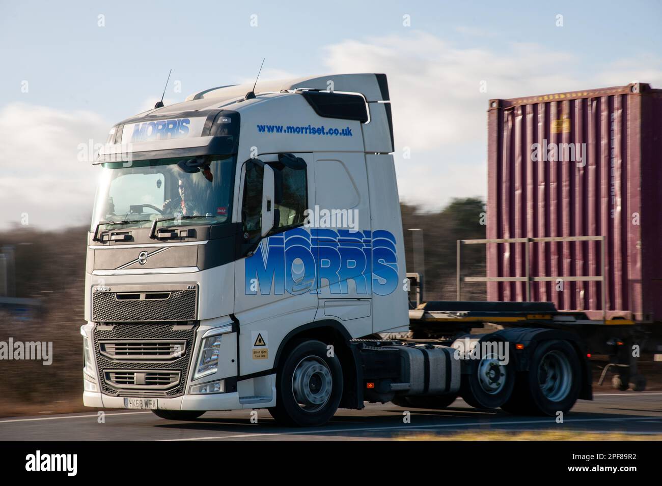 Camion Volvo FH tirant un conteneur d'expédition descendant une route glissante sur le A1 Banque D'Images