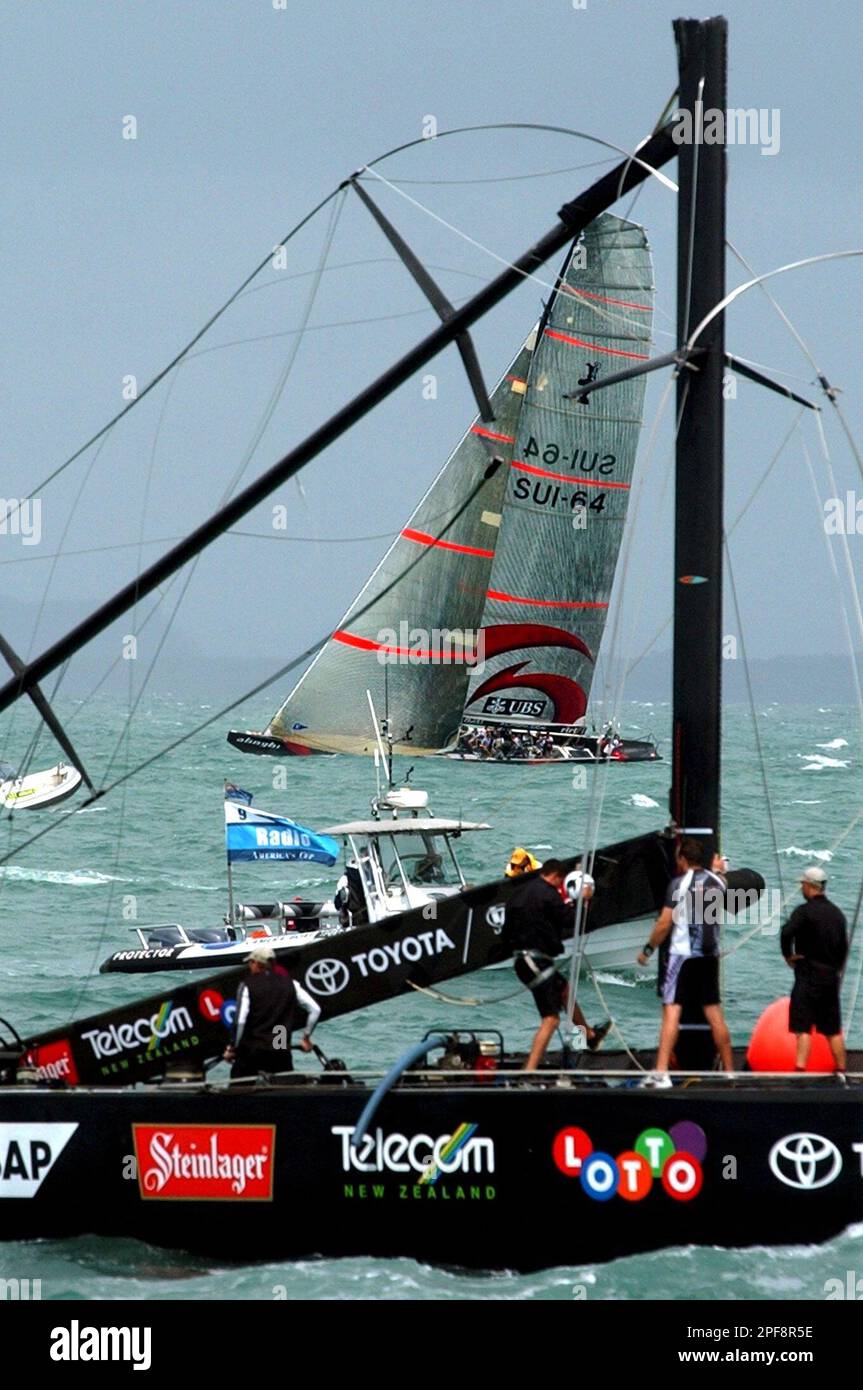 Swiss Defi yacht Alinghi, SUI-64, background, sails behind the New Zealander defender yacht, Team New Zealand, NZL-82, in front, after they broke their mast, during the fourth match-race of the America's Cup final, in Hauraki gulf, near Auckland , New Zealand, Friday, Feb. 28, 2003. Alinghi won the race while Team New Zealand did not finish due to a broken mast. Alinghi leads the best of nine series 4-0. (AP Photo/Keystone, Laurent Gillieron) Banque D'Images