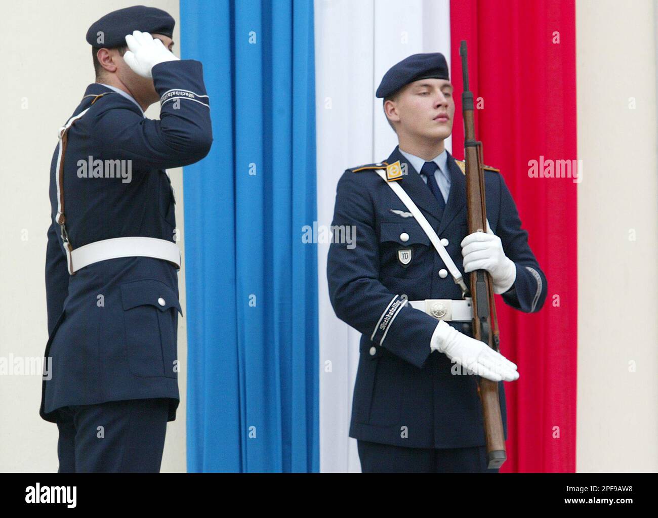 German Air Force soldiers salute as they stand in front of a French flag at the Bellevue Palace in Berlin, Thursday, Jan. 23, 2003. France and Germany celebrate the 40th anniversary of the Elysee friendship treaty Wednesday with a raft of events intended to inject new vitality into their relationship, which is pivotal in efforts to expand and integrate the European Union. (AP Photo/ Jockel Finck) Banque D'Images