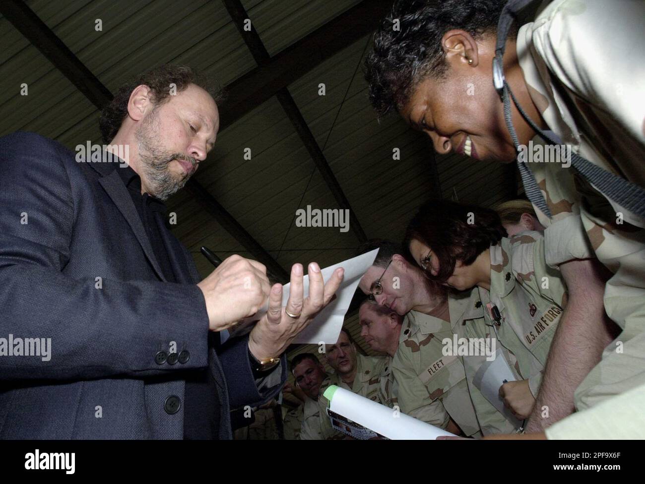 Actor Billy Crystal, left, signs autographs for the troops stationed at MacDill Air Force Base in Tampa, Fla., Wednesday afternoon, Dec. 4, 2002. Crystal, Robert De Niro and Kevin Spacey were visiting the base before premiering the new movie "Analyze That" for the troops. (AP Photo/Chris O'Meara) Banque D'Images