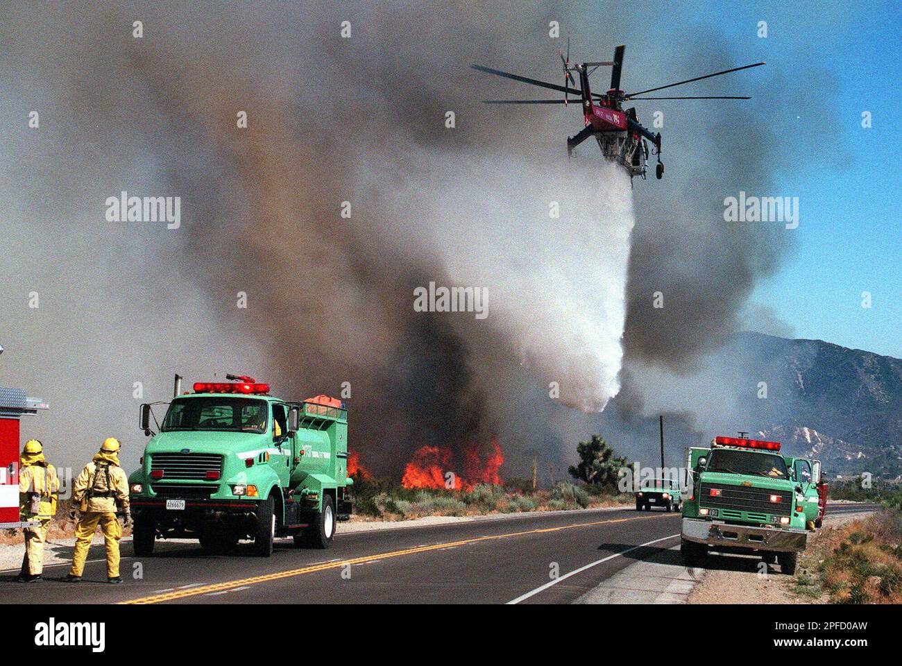 A U.S. Forest Service helicopter drops on a hot spot in the Cajon