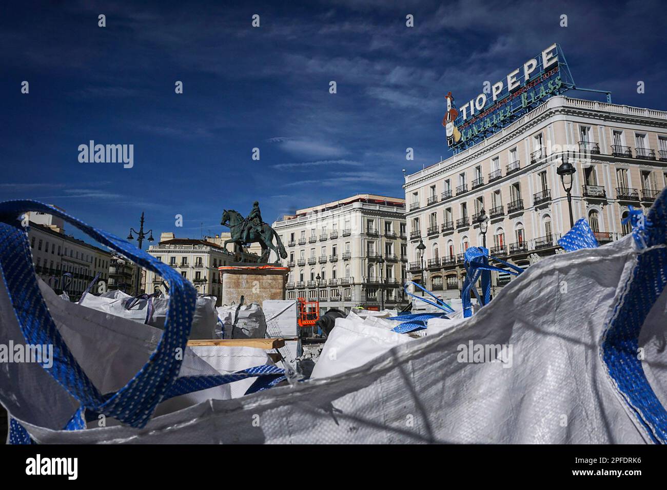 Madrid, Espagne. 16th mars 2023. La statue équestre de Carlos III (à  gauche) et le Tio Pepe annonçant la lumière parmi les sacs de décombres.  Les travaux qui sont en cours à