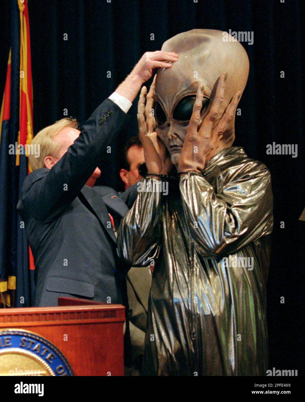 Arizona Gov. Fife Symington pulls a mask off of aide Jay Heiler, dressed up as an alien, during a late afternoon news conference at the state capitol in downtown Phoenix Thursday June 19, 1997. Symington, earlier in the day, said he would order the Arizona Department of Public Safety to look into the mysterious lights seen over Phoenix, but later insisted he was joking. (AP Photo/Scott Troyanos) Banque D'Images