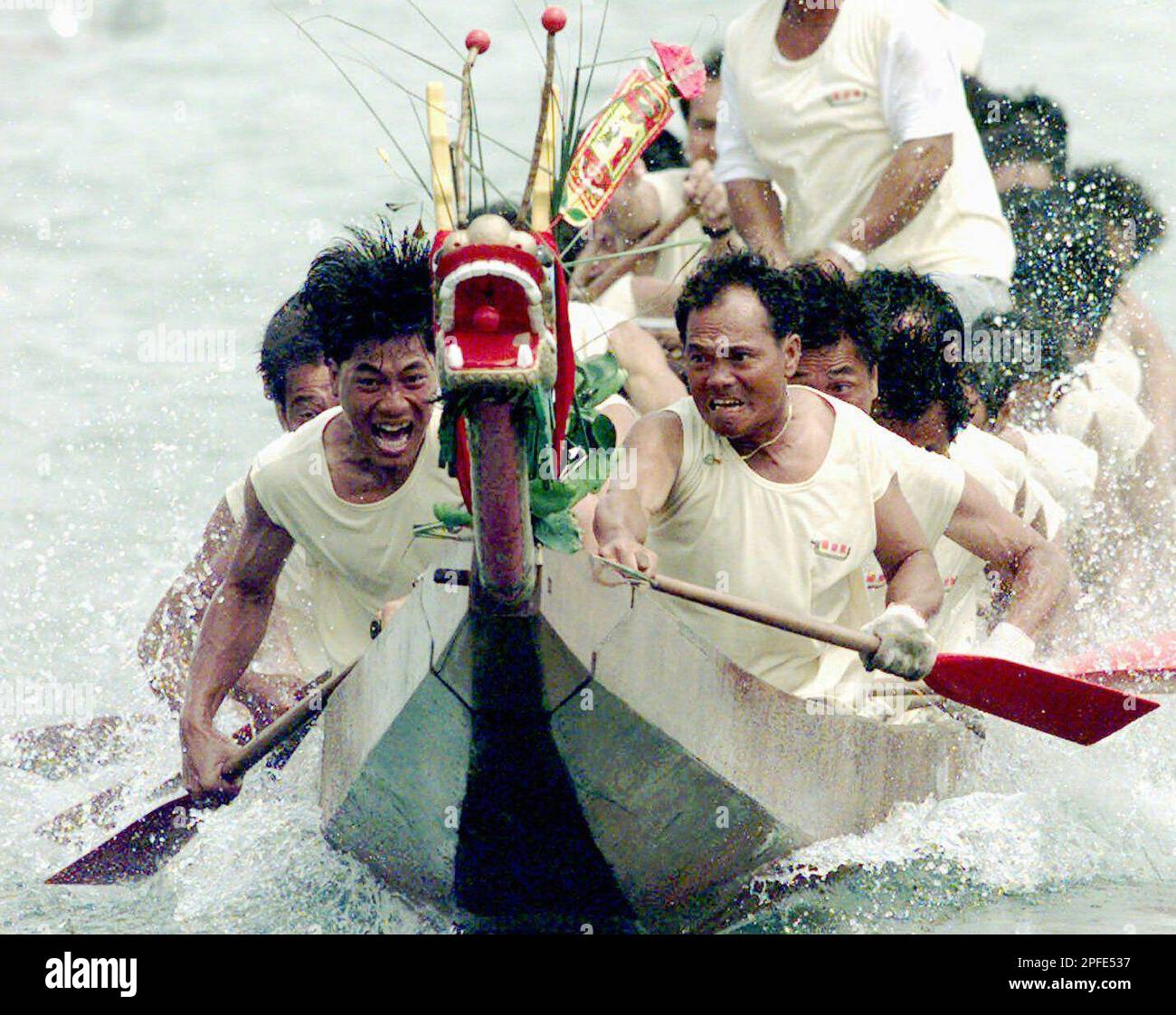 Fishermen participate in a dragon boat race near Hong Kong's Cheung Chau island Sunday, June 8, 1997 as part of celebrations marking the Chinese Dragon Boat Festival, when such races are held throughout Hong Kong. (AP Photo/Franki Chan) Banque D'Images