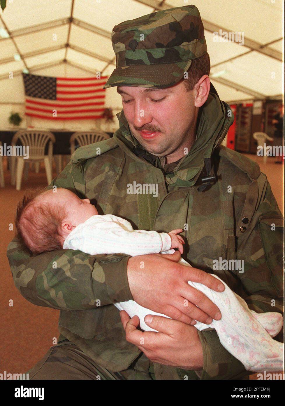 U.S. Army Spec. Russel Mills of Suffield, Conn., holds his baby Sydney, who was born one month and three days ago, at Rhein-Main Airport in Frankfurt, Germany, on Monday, April 15, 1996. Mills is seeing his baby for the first time in person since he was deployed with U. S. troops to Bosnia. About 135 U.S. soldiers arrived for two week break after they spent between four and five months in Bosnia. (AP Photo/Heribert Proepper) Banque D'Images