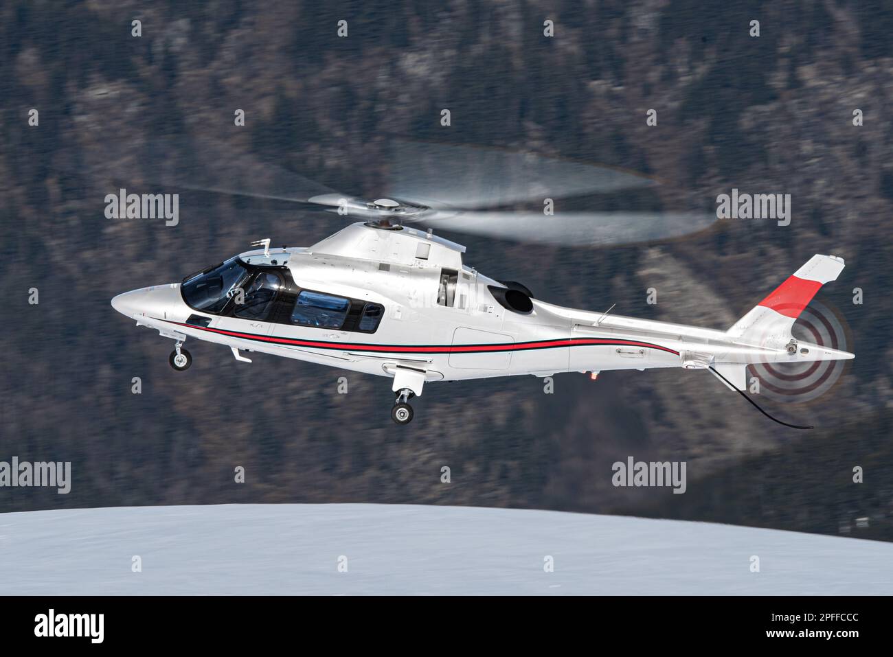 Hélicoptère Leonardo AW109 blanc et rouge dans les Alpes françaises près de Courchevel Banque D'Images