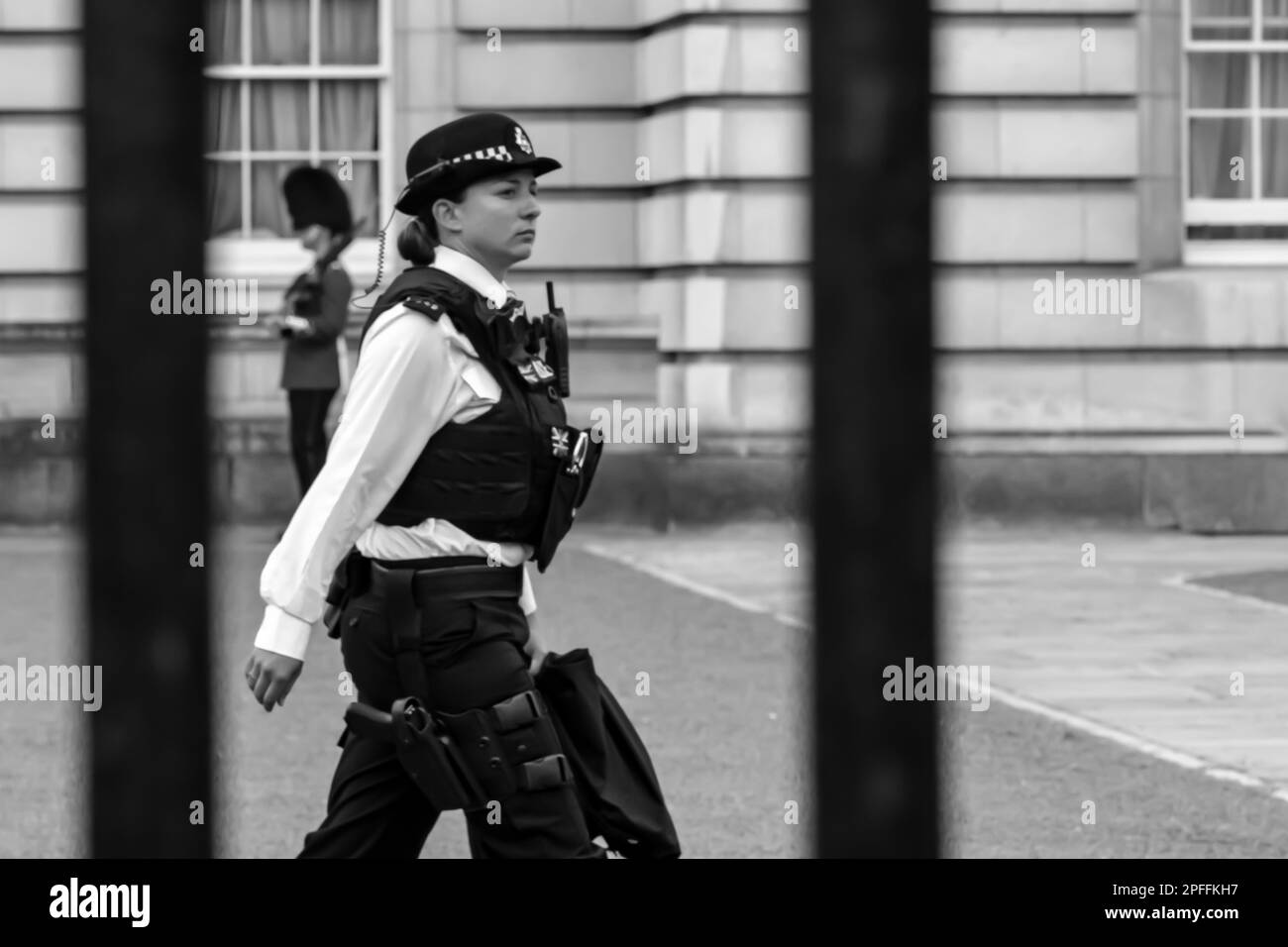 Londres, Royaume-Uni - 21 mai 2018 : vue d'une femme policier en face du Palais de Buckingham à Londres, Royaume-Uni, en noir et blanc Banque D'Images