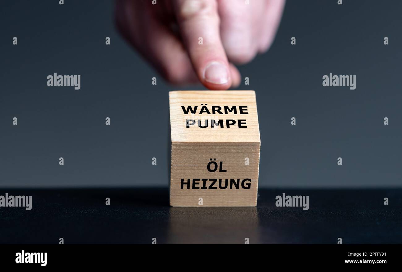 Symbole de l'interdiction des systèmes privés de chauffage à l'huile en Allemagne. La main tourne le cube et change l'expression allemande 'Oelheizung' (chauffage à l'huile) en 'Waermep Banque D'Images