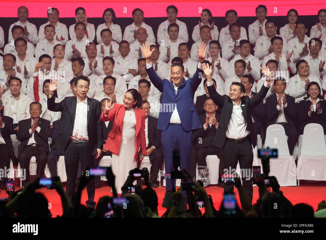 Panthongtae Shinawatra, son of Thaksin Shinawatra, left, to right Paetongtarn Shinawatra, one of the opposition Pheu Thai party's top politicians it is set to nominate to become the next prime minister, Srettha Thavisin, a real estate tycoon and advisor to the opposition Pheu Thai party, and Pheu Thai party leader Chonlanan Srikaew wave to supporters at Thammasat University's indoor gymnasium in Pathum Thani province north of Bangkok, Thailand, on Friday, March 17, 2023. Thailand’s largest opposition party unveiled on Friday a list of policies and 400 prospective candidates they will be fieldi Banque D'Images