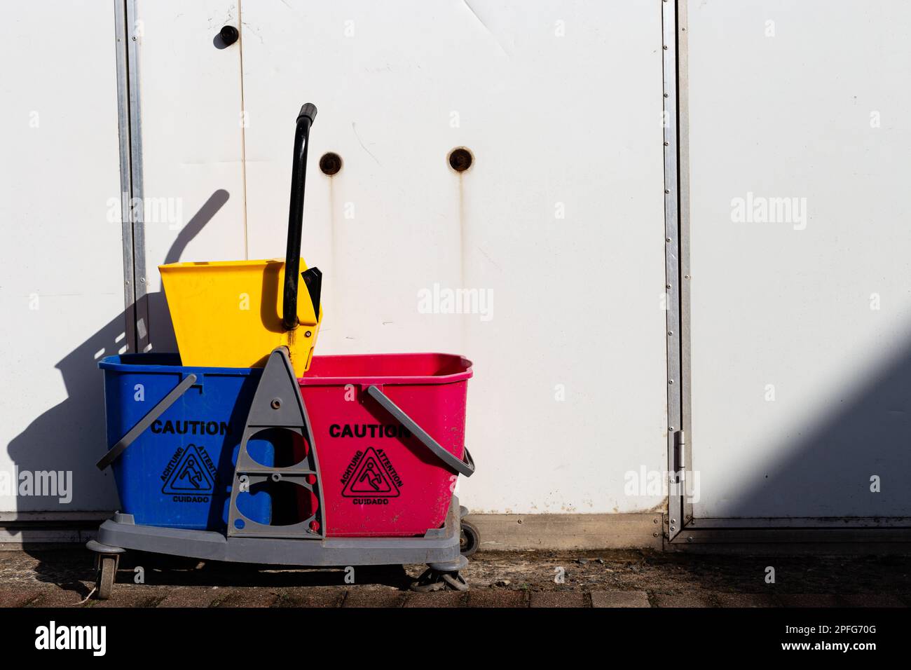 Panneau de mise en garde sur les seaux de nettoyage multicolores, photographiés dans un restaurant local de Durban. Banque D'Images