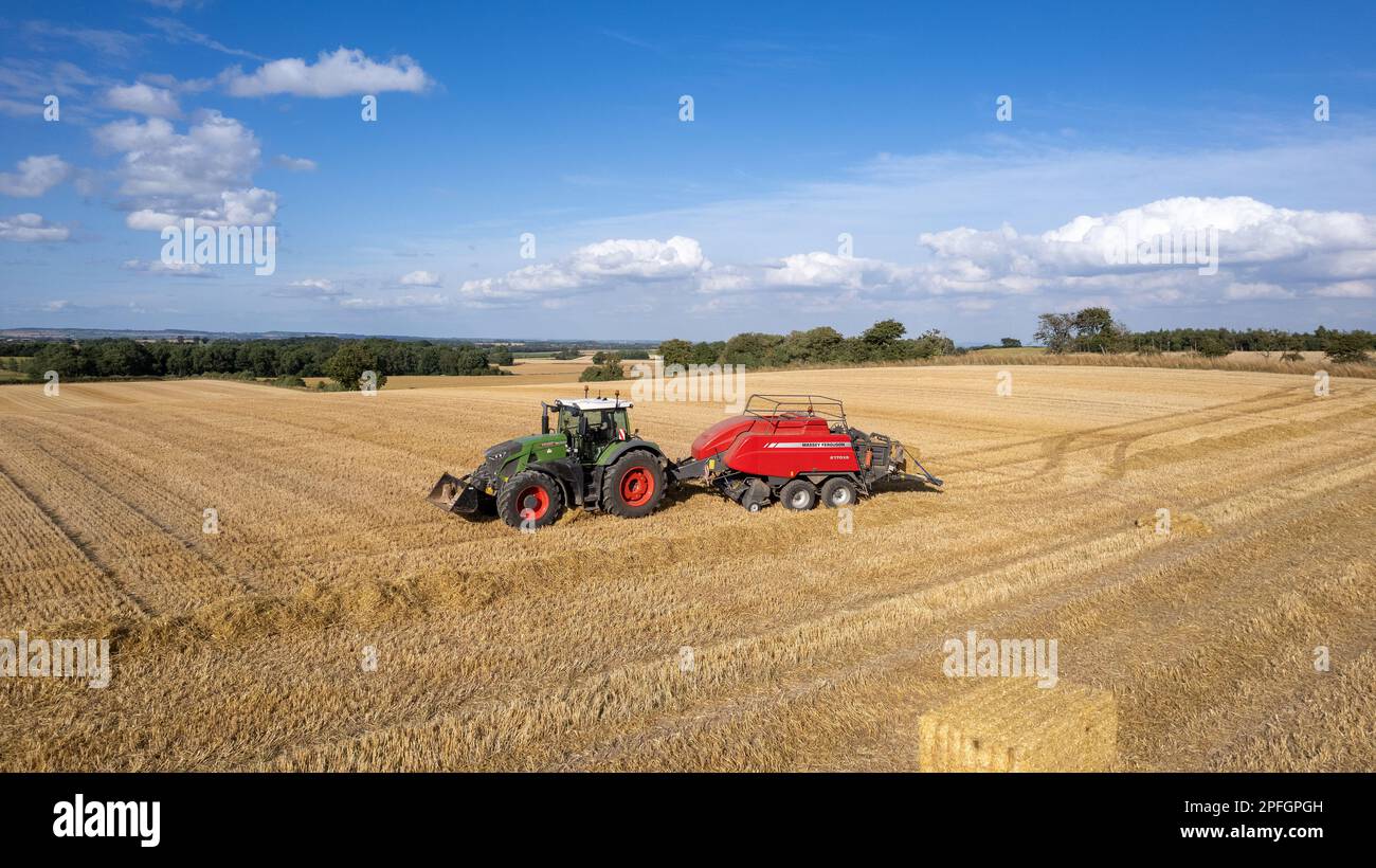 Agriculteur qui a mis en balles de grosses balles de paille avec une presse à balles Massey Ferguson 2170XD et un tracteur Fendt, North Yorkshire, Royaume-Uni. Banque D'Images