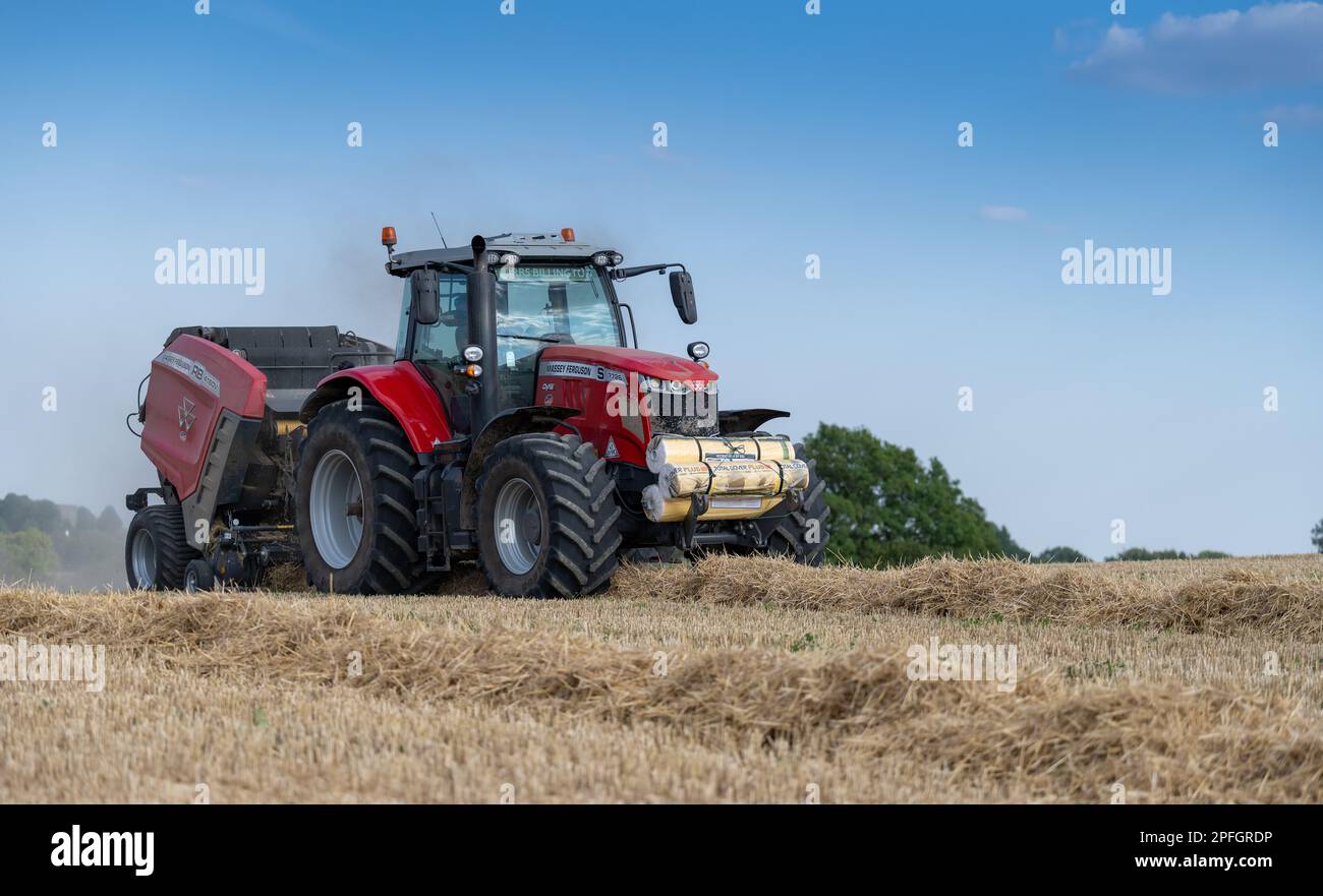 Pressage de paille en balles rondes avec un tracteur Massey Ferguson 7726 et une presse à balles RB4160v. La paille sera utilisée pour la litière des animaux. North Yorkshire, Royaume-Uni. Banque D'Images