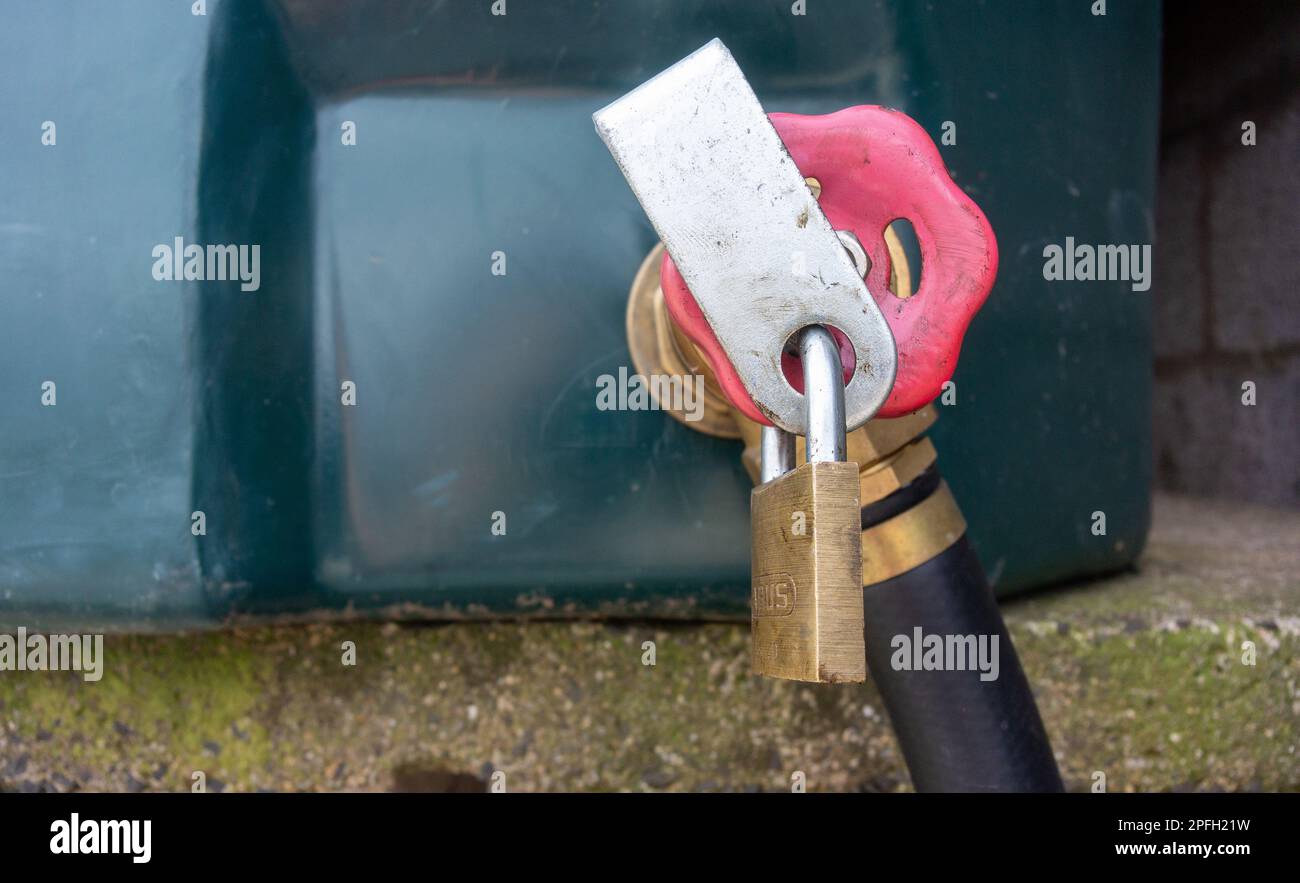 Cadenas sur un réservoir diesel rouge dans une ferme pour aider à prévenir le vol. North Yorkshire, Royaume-Uni. Banque D'Images