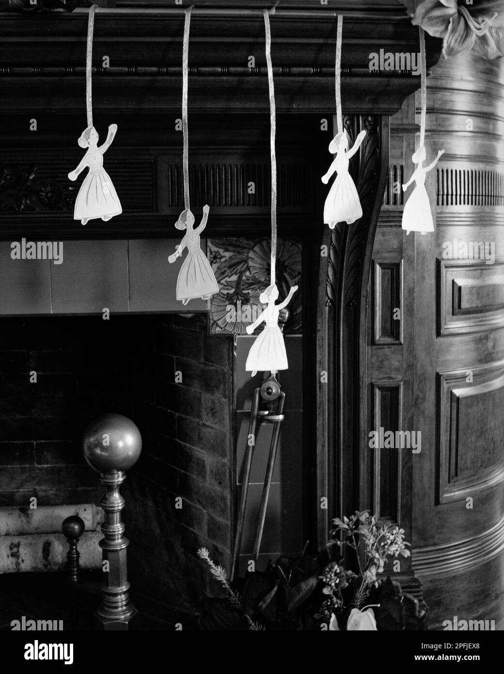 Des décorations de Noël en papier sont suspendues à des rubans au-dessus d'une cheminée avec un soleil chaud qui diffuse la fenêtre à proximité du domaine 1878 Eustis. La maison est stu Banque D'Images