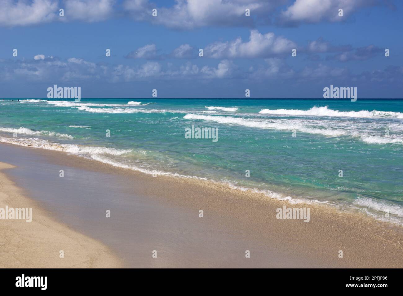 Plage tropicale avec sable sur un océan, vue sur les vagues d'azur et le ciel avec des nuages. Côte des Caraïbes, arrière-plan pour des vacances sur une nature paradisiaque Banque D'Images