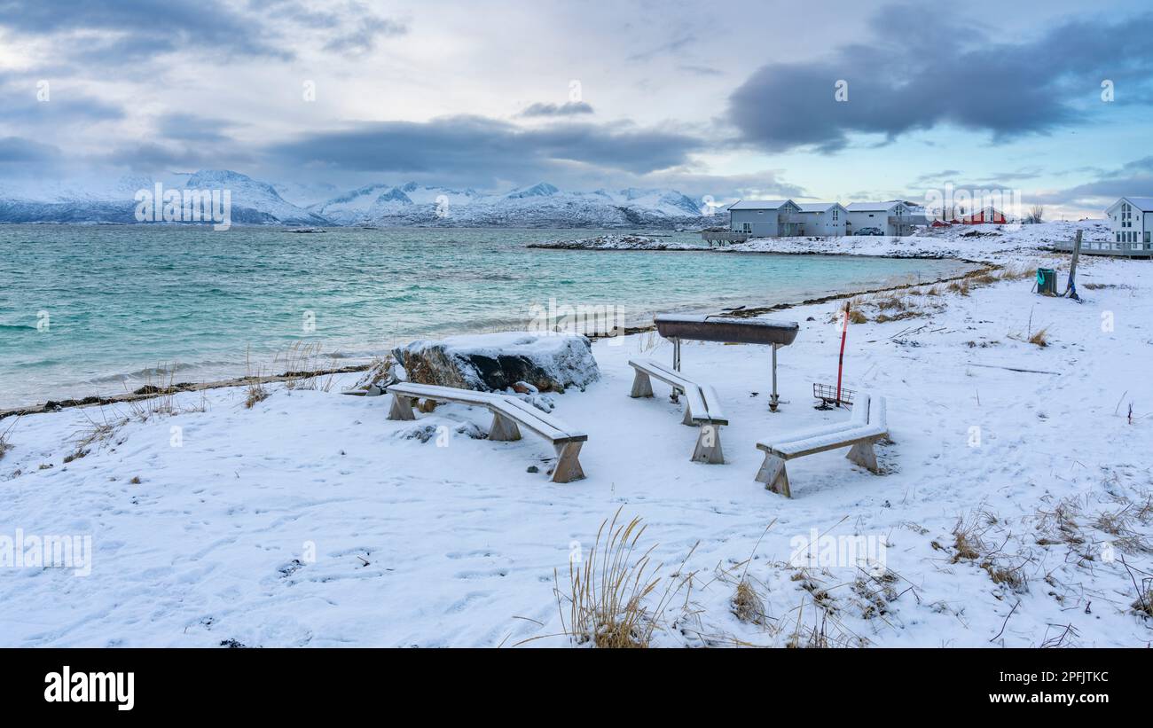 Sitzbereich am Strand von Hillesøya, Grillplatz am Ufer des Nordatlantiks à Troms, Norwegen. Morgenstimmung am verschneiten Strand der Insel Sommarøy Banque D'Images