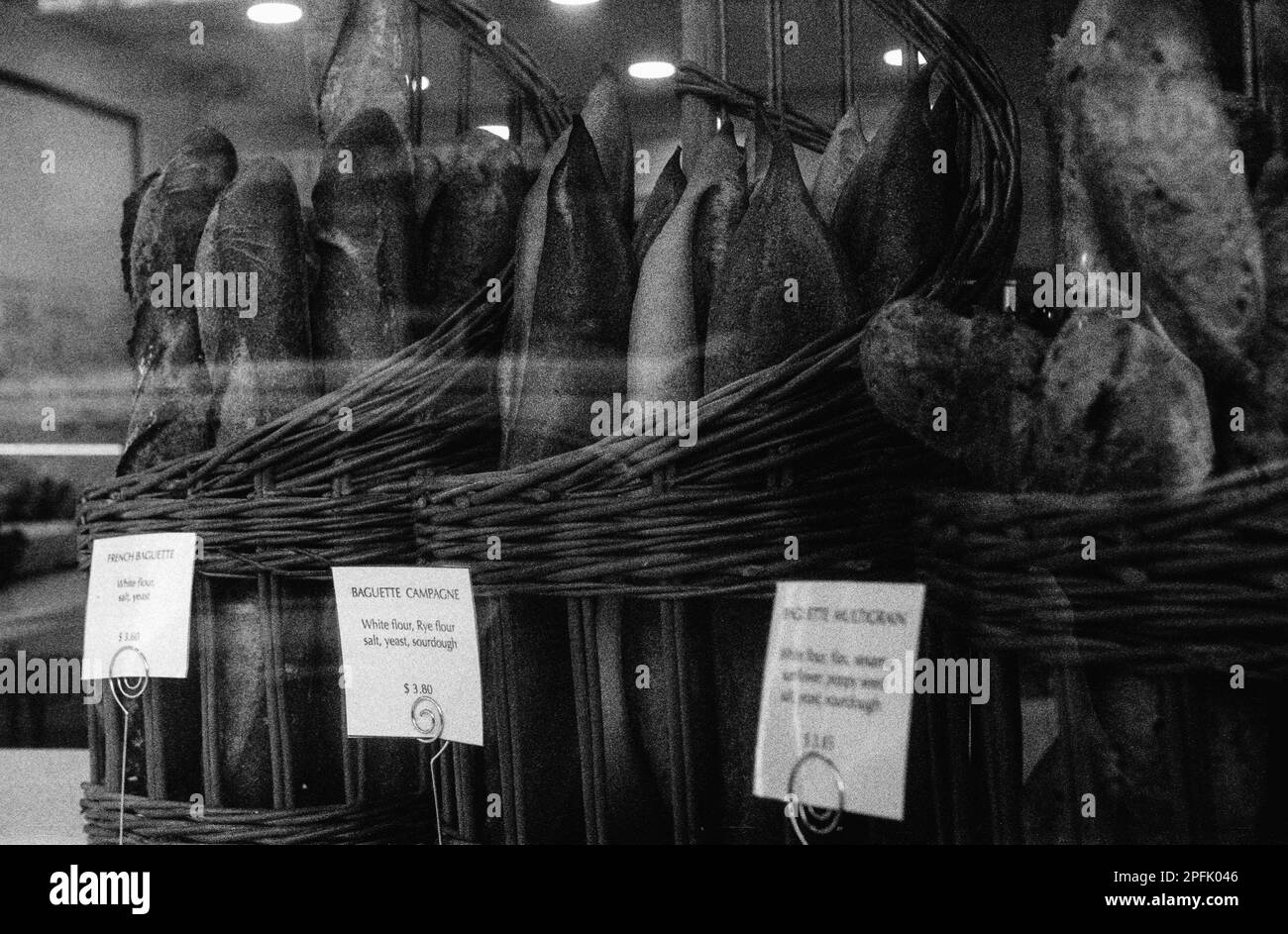 Baguettes de pain frais en paniers dans la fenêtre d'une boulangerie française à Melrose, Massachusetts. L'image a été capturée en noir et blanc analogique Banque D'Images