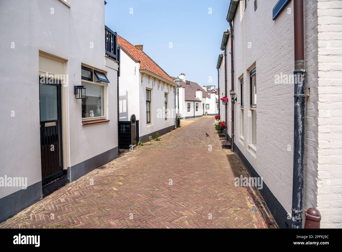 Rue étroite bordée de chalets de vacances blancs dans une ville de bord de mer par une belle journée d'été Banque D'Images