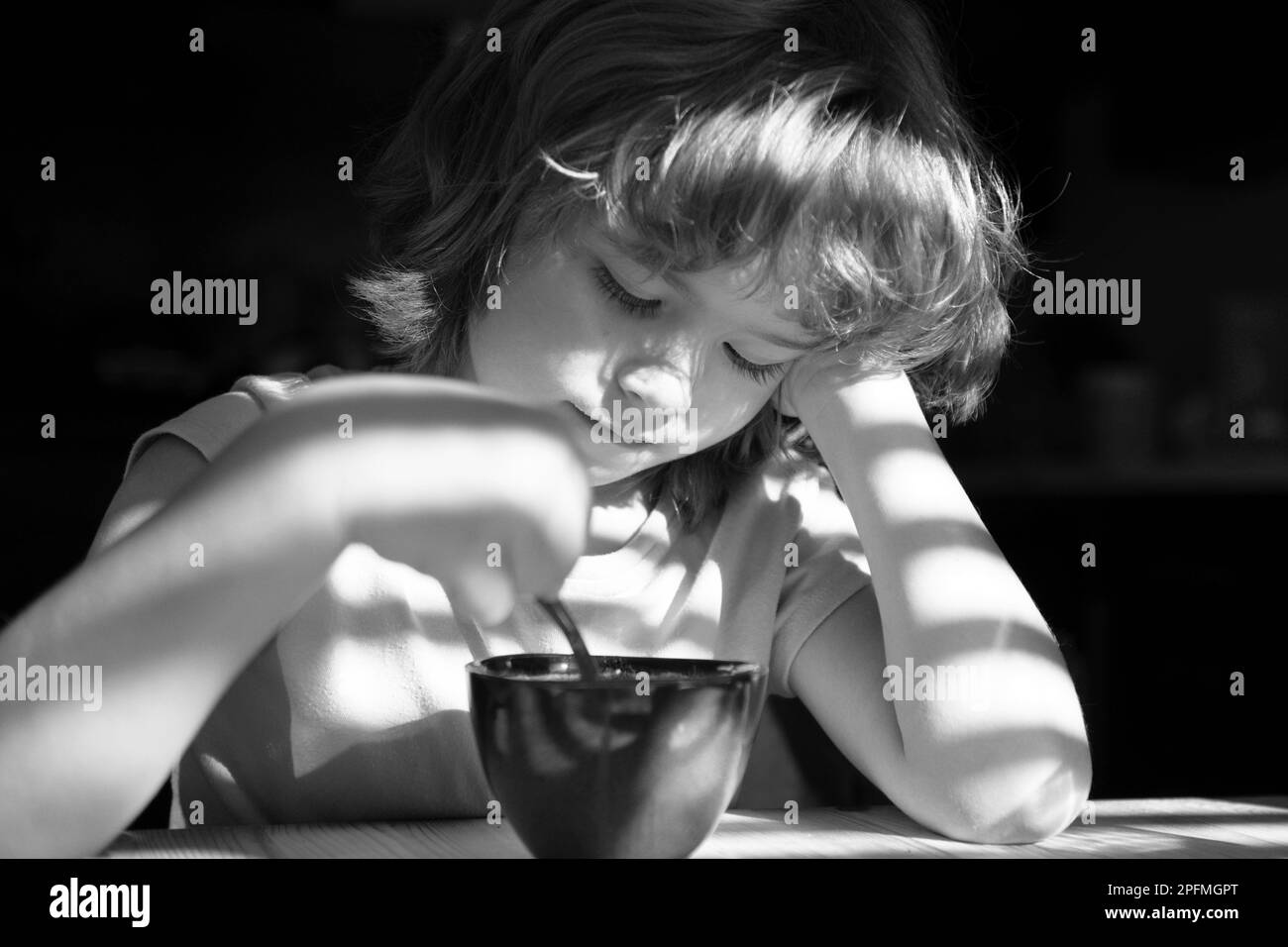 Nutrition et habitudes alimentaires saines pour les enfants. Nourriture maison. Le garçon mange le petit déjeuner dans la cuisine. Banque D'Images