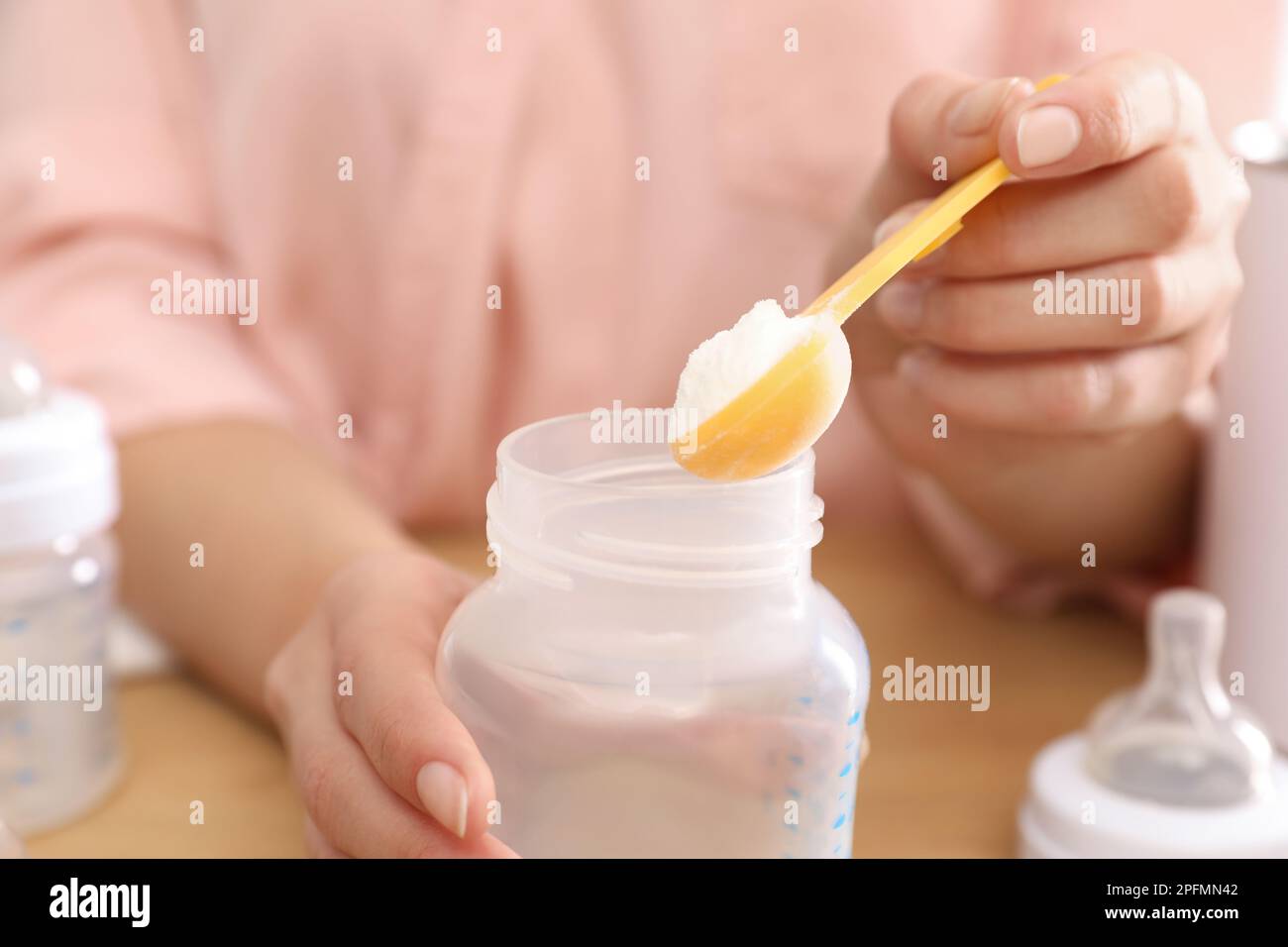 Femme préparant des préparations pour nourrissons à la table, en gros plan. Lait pour bébé Banque D'Images