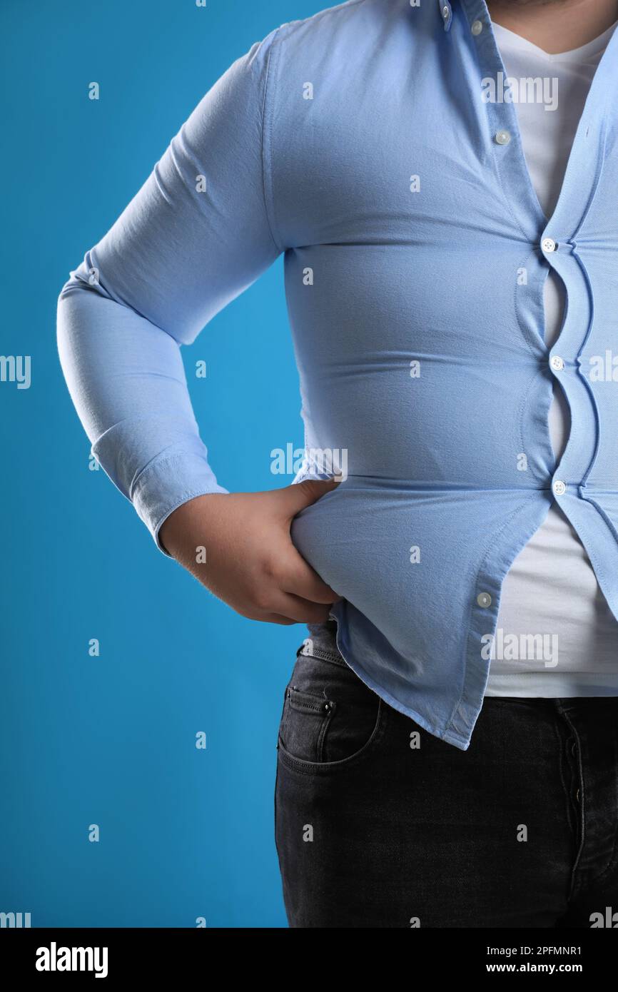 Homme en surpoids dans une chemise serrée sur fond bleu clair, gros plan  Photo Stock - Alamy