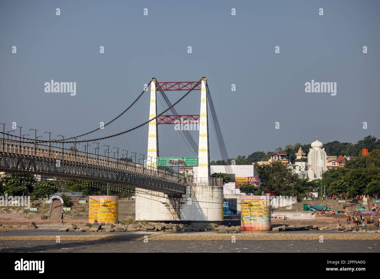 Pont de câble, Lakshman ou RAM Jhula, un pont suspendu à Rishikesh avec trois couleurs de drapeau national indien. Vue depuis le bord de la rivière. Banque D'Images