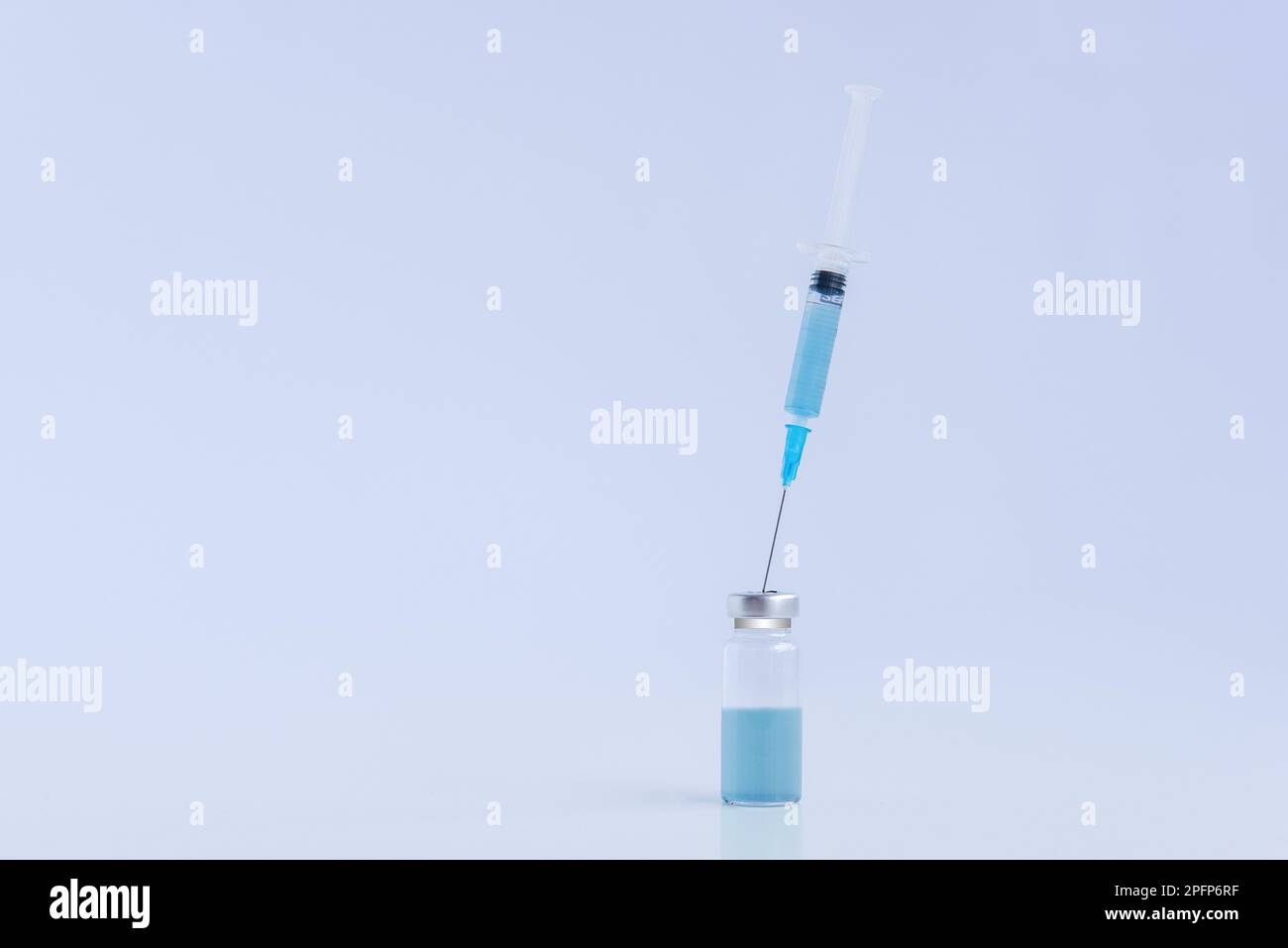 Sur fond blanc isolé, flacon en verre transparent avec vaccin bleu contre les virus avec seringue jetable. Lutte contre les épidémies d'infection. Co Banque D'Images