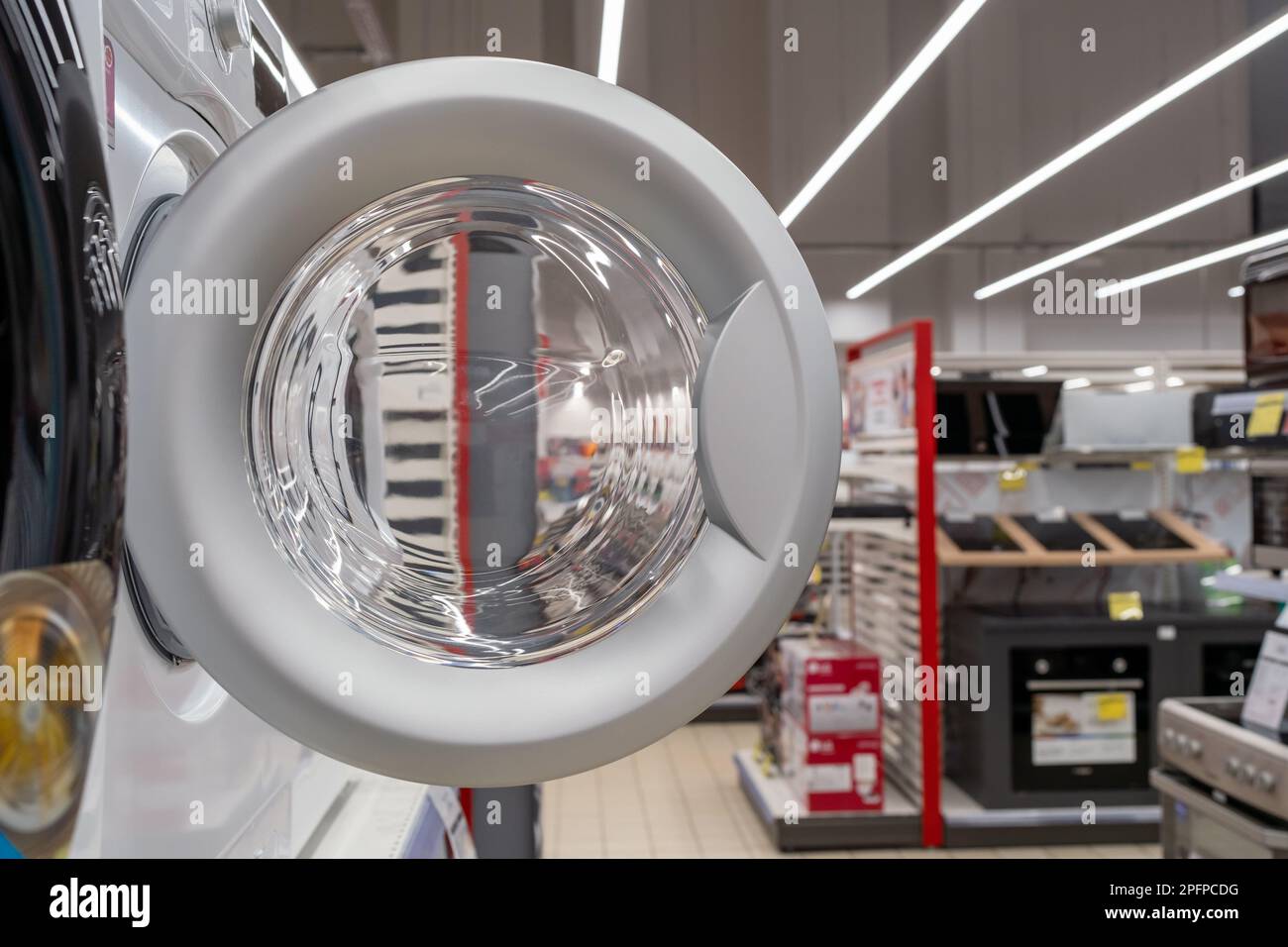 Ouvrez la porte d'un lave-linge dans un magasin d'appareils ménagers. Banque D'Images