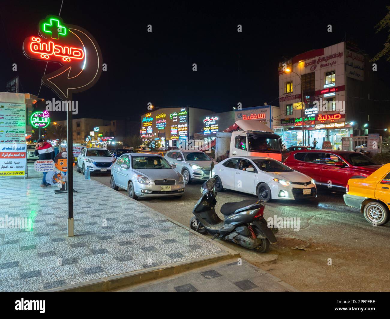 Bagdad, Irak - 20 février 2023 : vue de nuit sur la rue Al-Maghreb, connue pour ses nombreuses cliniques médicales et pharmacies. Banque D'Images