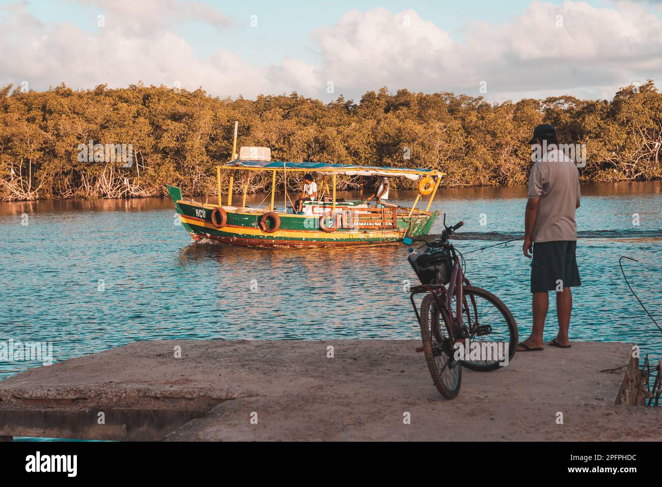 Valentica, Bahia, Brésil - 09 septembre 2022 : bateau naviguant sur la rivière una en fin d'après-midi tout en pêchant à la maison sur la rive. Ville de Valenca, Banque D'Images