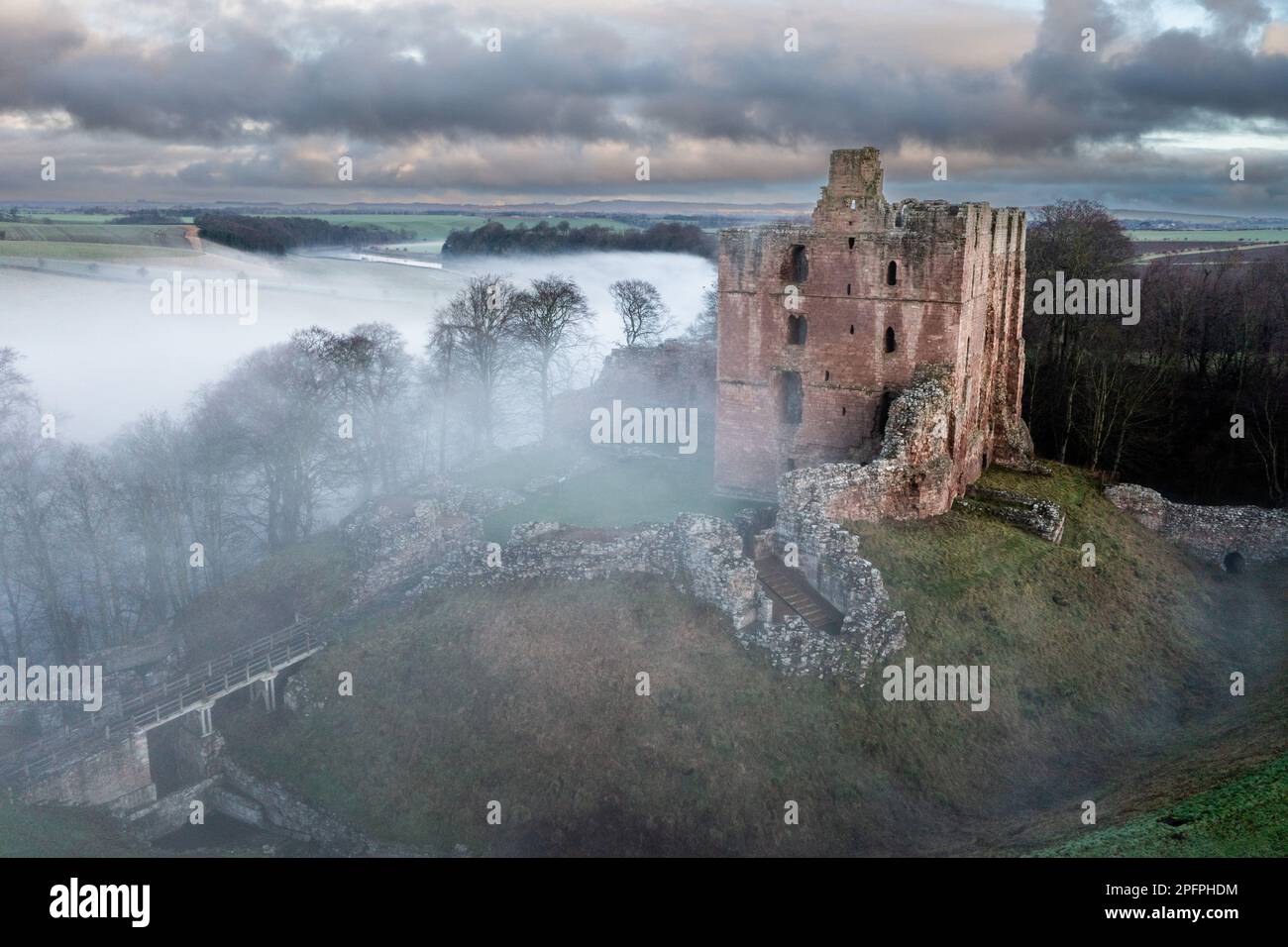 La brume sur la rivière entoure le château de Norham, situé au-dessus de la rivière Tweed qui garde la frontière anglo-écossaise, Northumberland, Angleterre, Royaume-Uni Banque D'Images