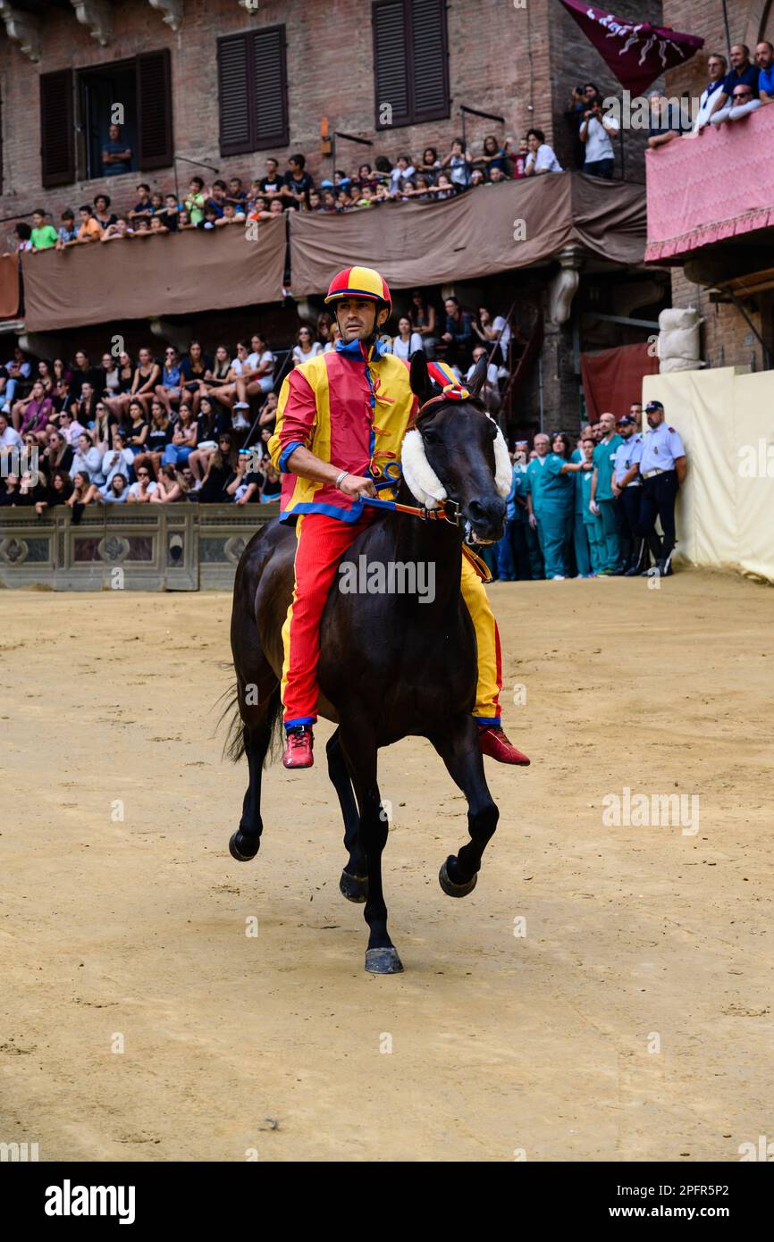Sienne, Italie - 15 août 2022: Pilote et cheval à la course d'essai de Palio di Siena Prova, Jockey ou Fantino Scompiglio Jonatan Bartoletti équitation pour Chio Banque D'Images