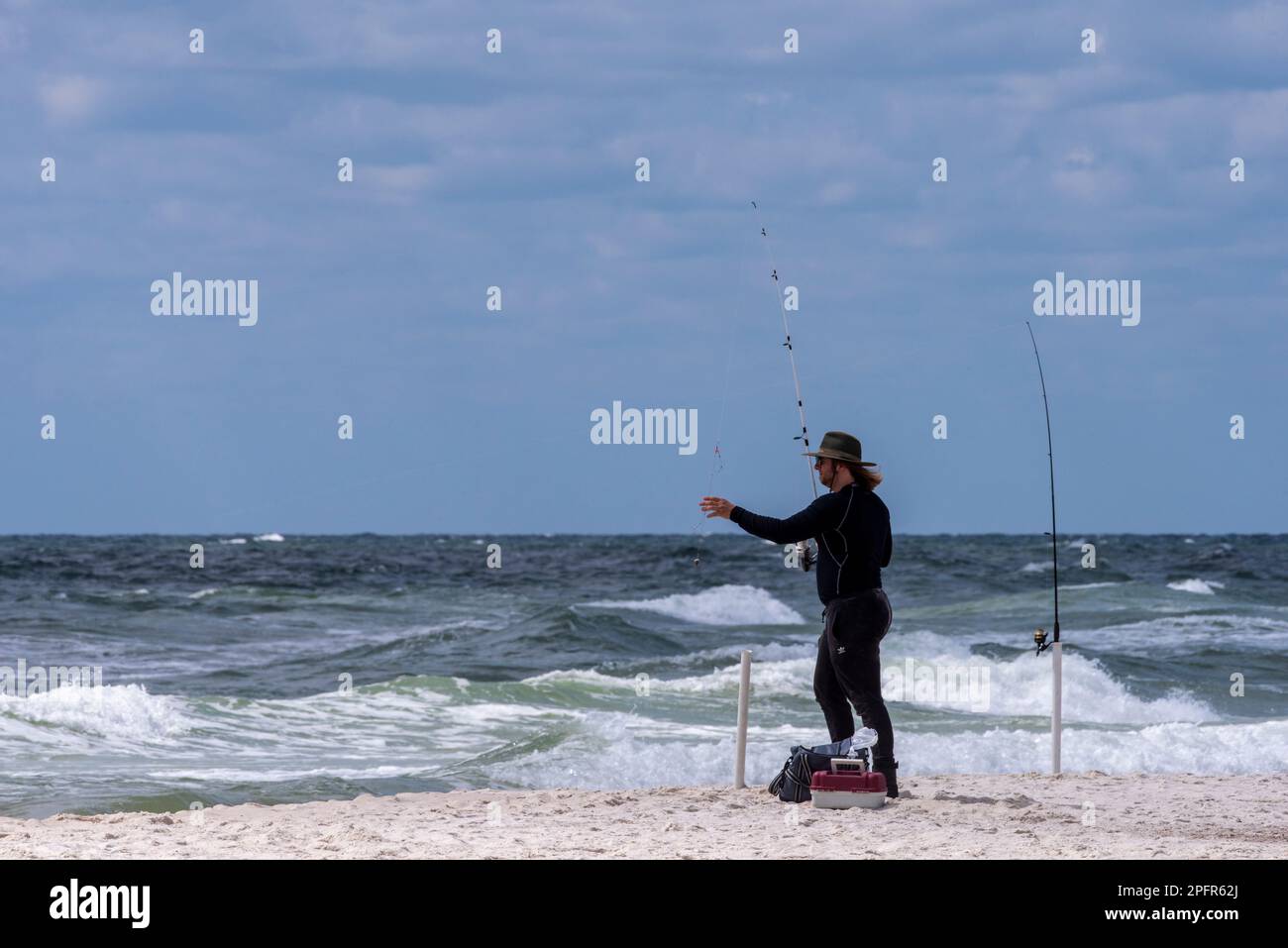 Un pêcheur se fait une idée de ses lignes sur la plage de Perdido Key en Floride sur 16 mars 2023. Banque D'Images