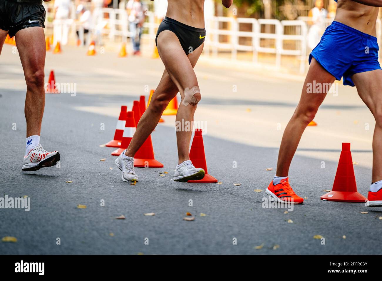 Les jambes regroupent les athlètes masculins et féminins en compétition, les chaussures de sport pour la marche Adidas et Asics et les shorts Nike Banque D'Images
