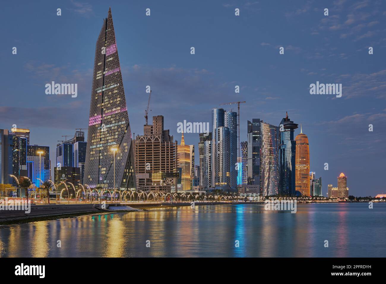 Doha Qatar Skyline de la promenade de corniche au crépuscule montrant les gratte-ciel de West Bay lumières reflétées dans le golfe arabe Banque D'Images