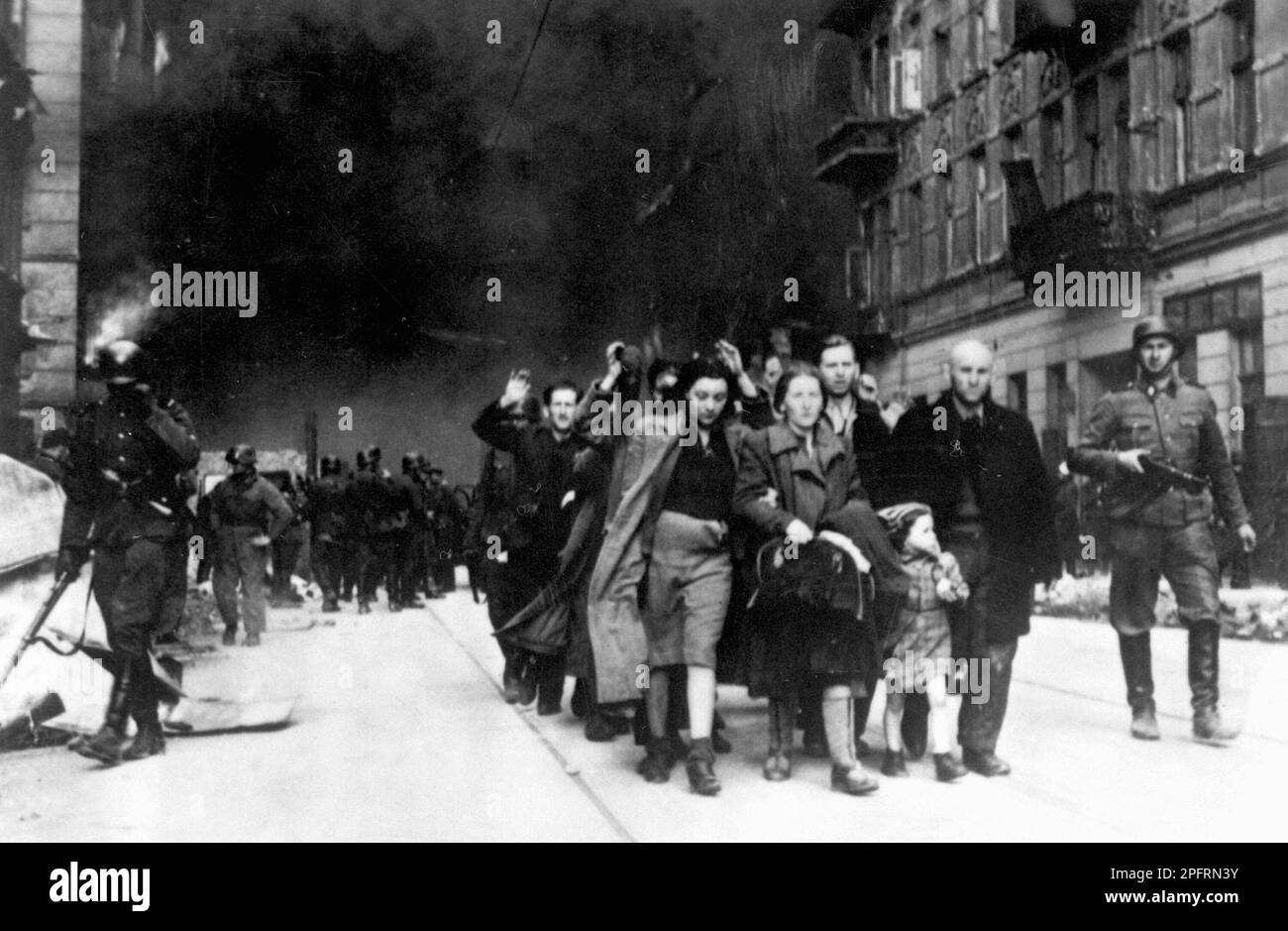 En janvier 1943, les nazis sont arrivés pour arrondir les Juifs du ghetto de Varsovie les Juifs, résolus au combattre, ont pris la SS avec des armes maison et primitives. Les défenseurs ont été exécutés ou déportés et la zone du ghetto a été systématiquement démolie. Cet événement est connu sous le nom de soulèvement du ghetto. Cette image montre une colonne de femmes capturées quittant la ville en feu. Cette image est tirée du dossier photographique allemand de l'événement, connu sous le nom de rapport Stroop. Banque D'Images