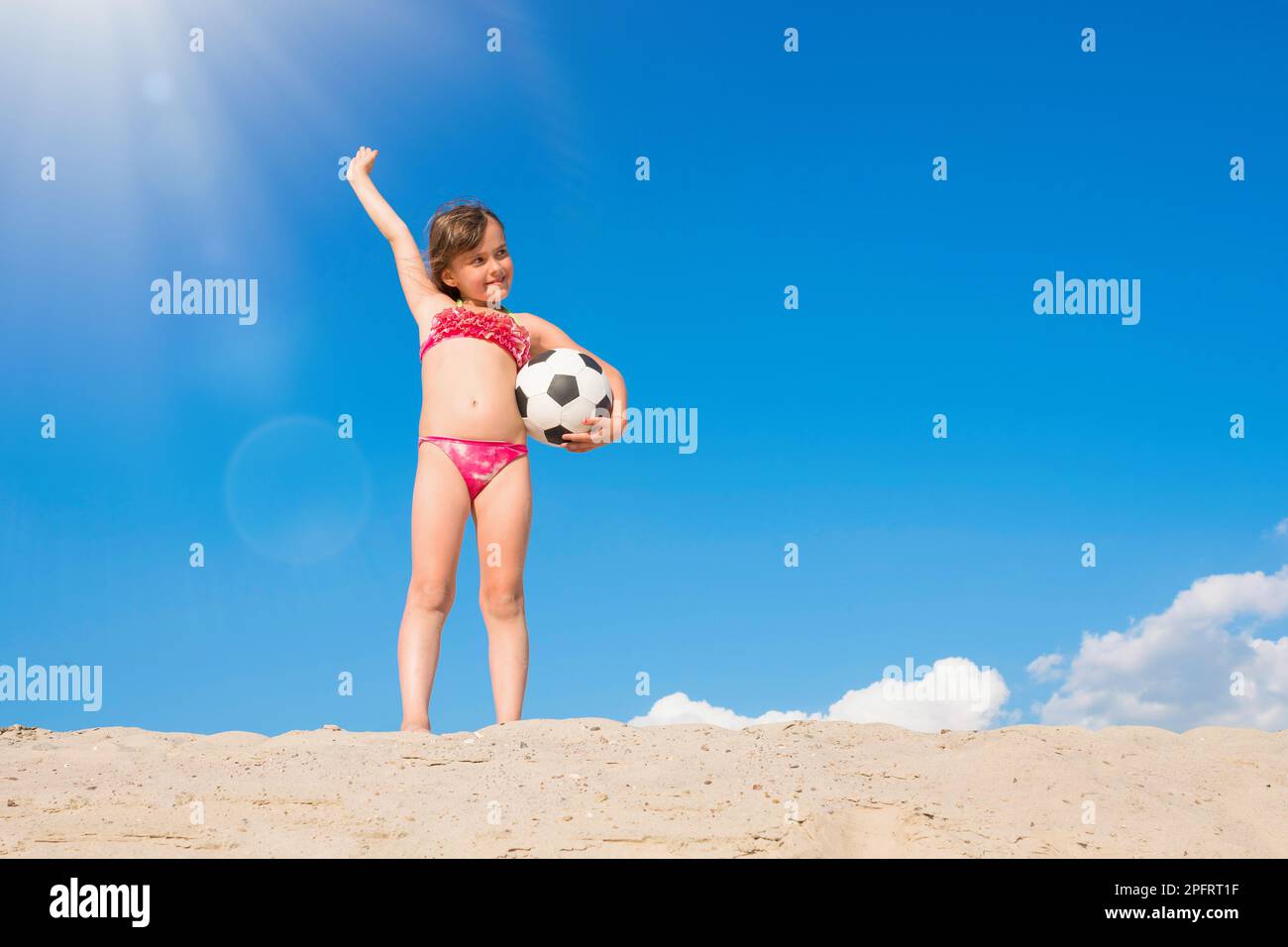 Bonne petite fille a du plaisir à jouer sur la plage lors d'une journée ensoleillée d'été. Un mode de vie sain. Banque D'Images