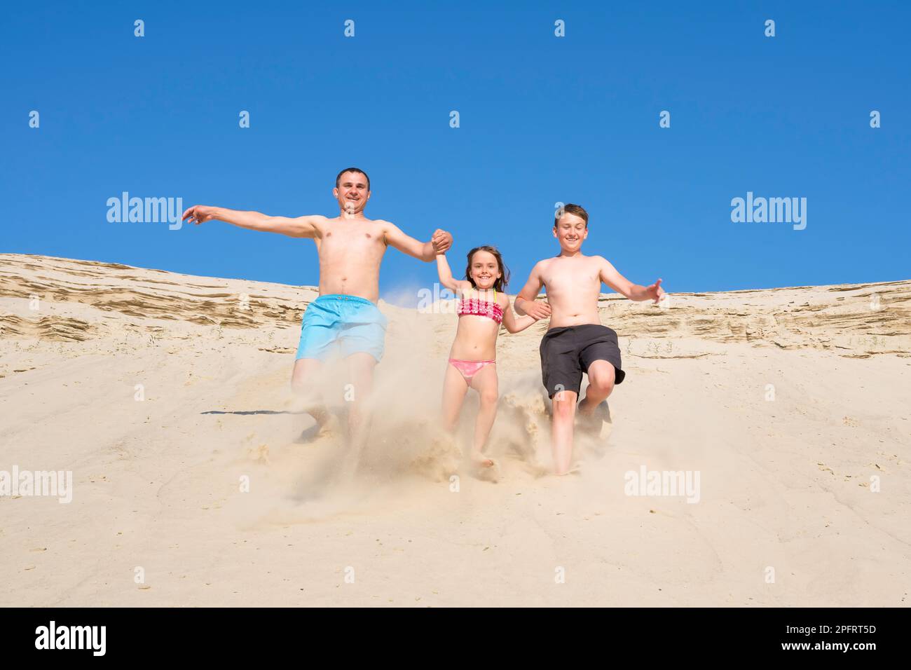 Famille heureuse, père avec son fils et fille courant sur la plage de sable, vacances d'été en mer active ensemble, famille, joie, sport, style de vie, week-end Banque D'Images