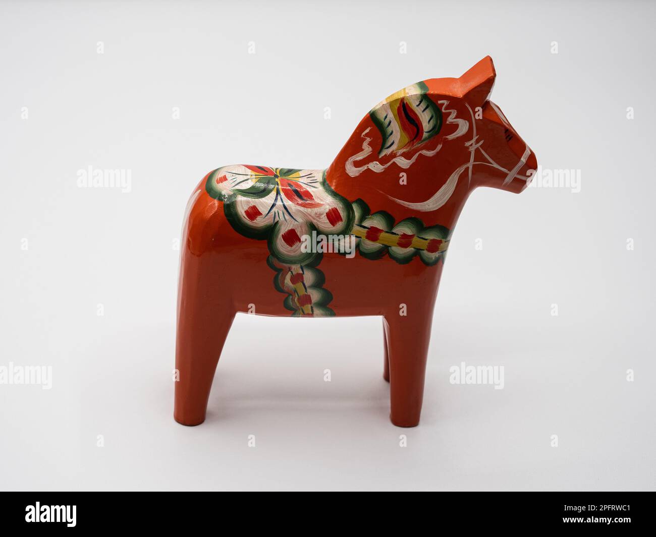 Le Dala Horse suédois traditionnel (Dalahäst) peint dans de nombreuses couleurs vues du côté sur fond blanc. Banque D'Images Le Dala Horse suédois traditionnel (Dalahäst) peint dans de nombreuses couleurs vues du côté sur fond blanc. Banque D'Images
