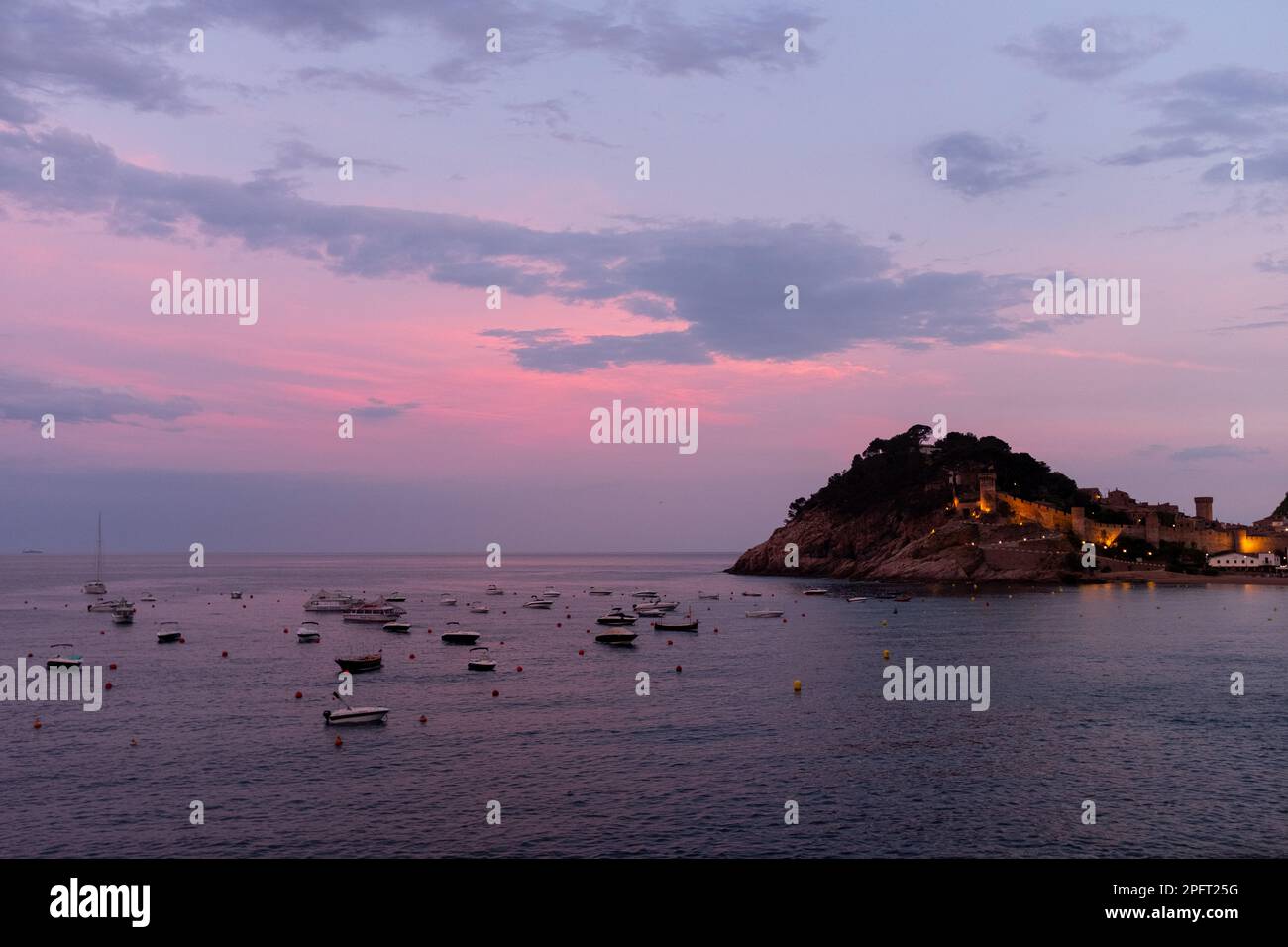 Les belles couleurs d'un coucher de soleil sur Tossa de Mar, Espagne, reflètent les eaux calmes de la mer Banque D'Images