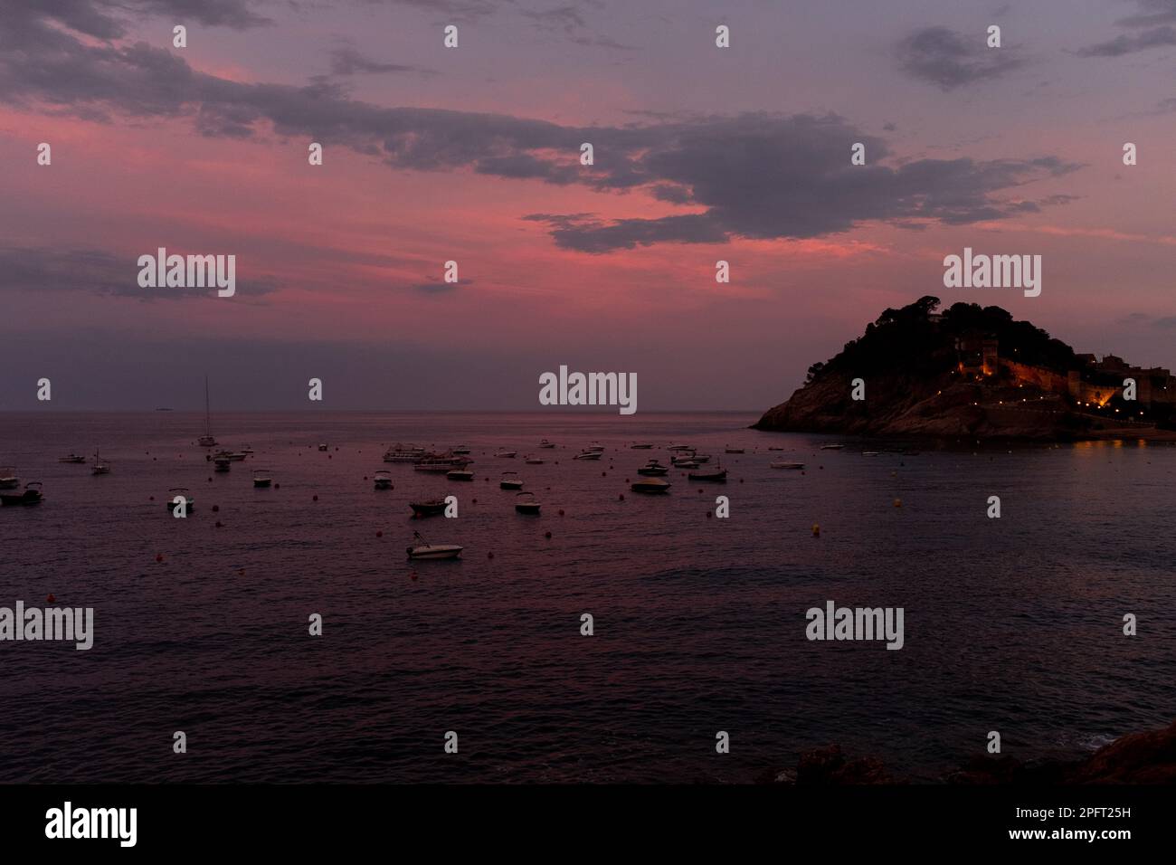 Les belles couleurs d'un coucher de soleil sur Tossa de Mar, Espagne, reflètent les eaux calmes de la mer Banque D'Images