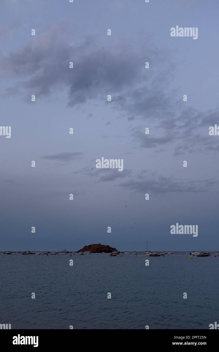 Le soleil se couche sur les sables dorés de Tossa de Mar, en Espagne, et diffuse une lumière chaude sur la plage Banque D'Images