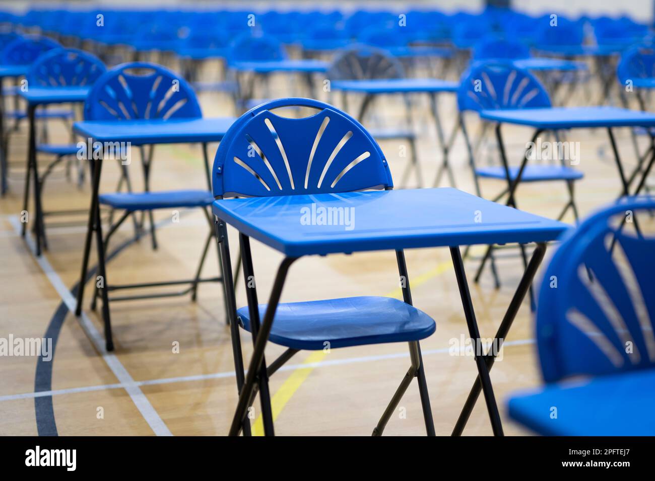 Des pupitres d'examen sont disposés dans une salle d'école. Banque D'Images